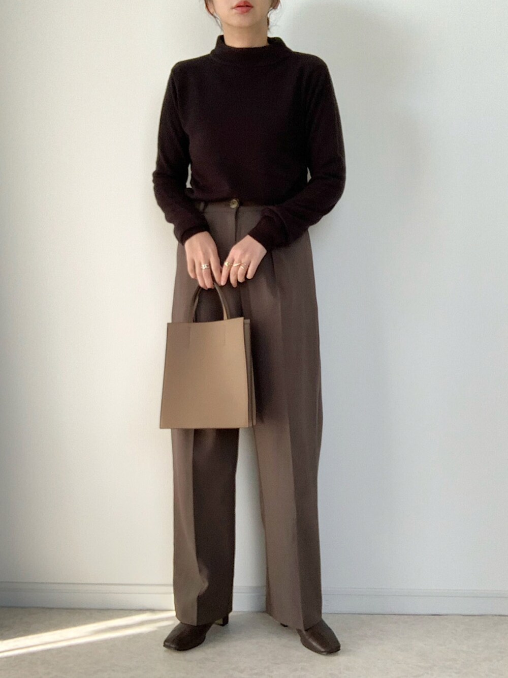 ベージュ系のカーディガン/ボレロ、ブラック系のニット/セーター、ブラウン系のスラックスを着用したレディースの秋コーディネートの3枚目の写真