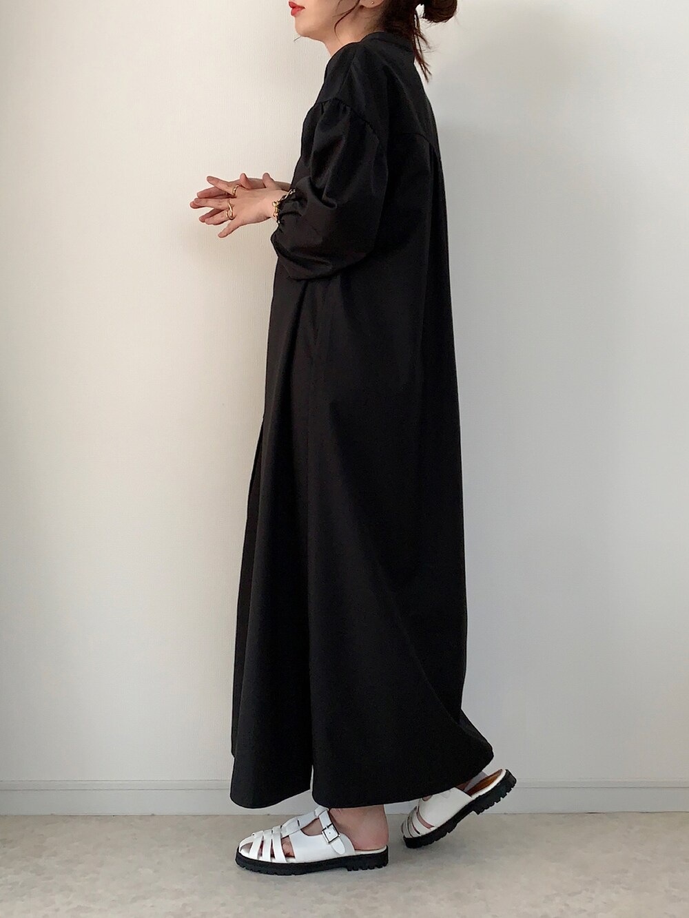 ブラック系のシャツワンピース、ホワイト系のトートバッグ、ホワイト系のサンダルを着用したレディースの夏コーディネートの2枚目の写真