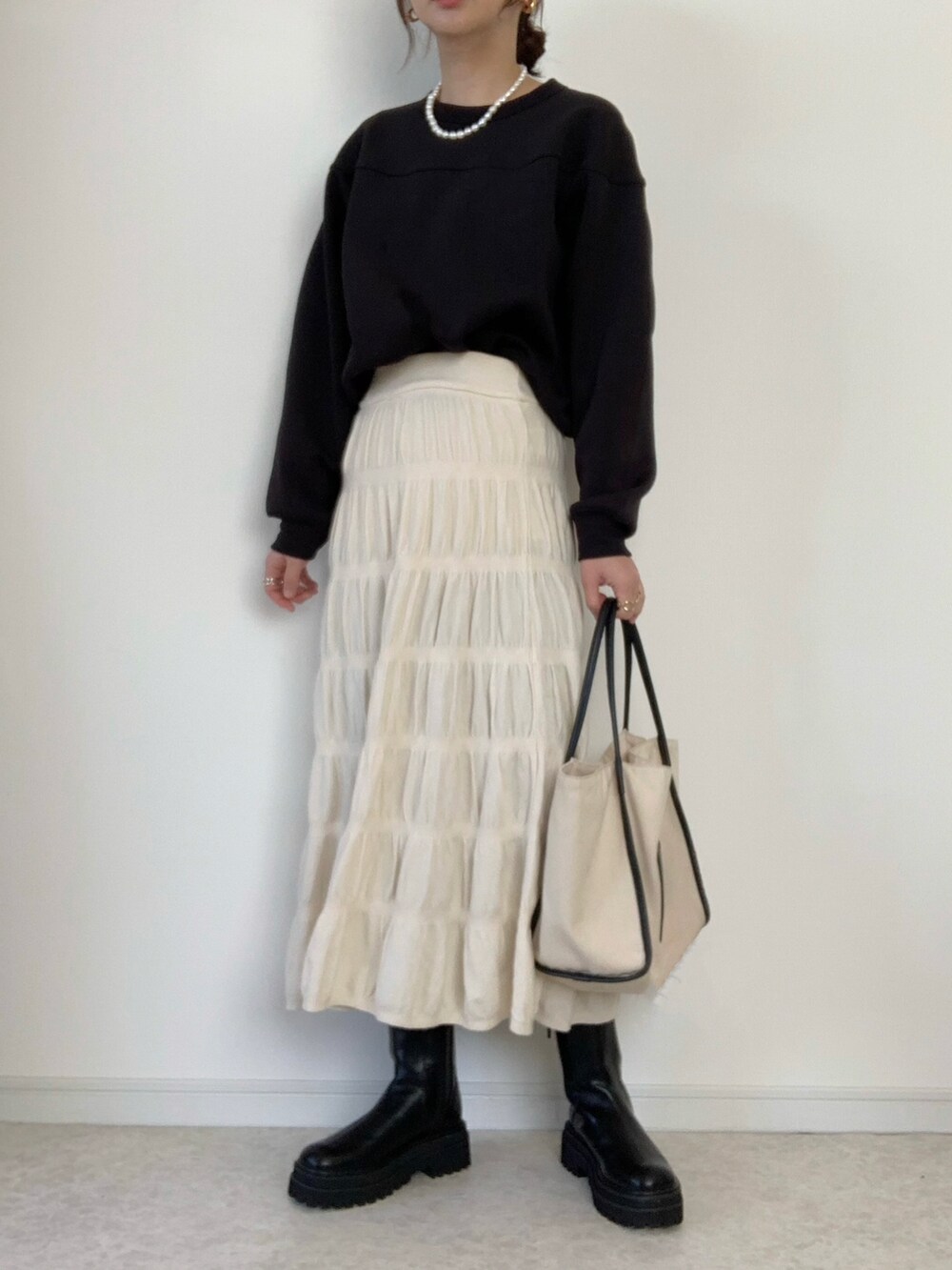 ブラック系のブルゾン、ホワイト系のトートバッグ、ブラック系のスウェットを着用したレディースの冬コーディネートの2枚目の写真