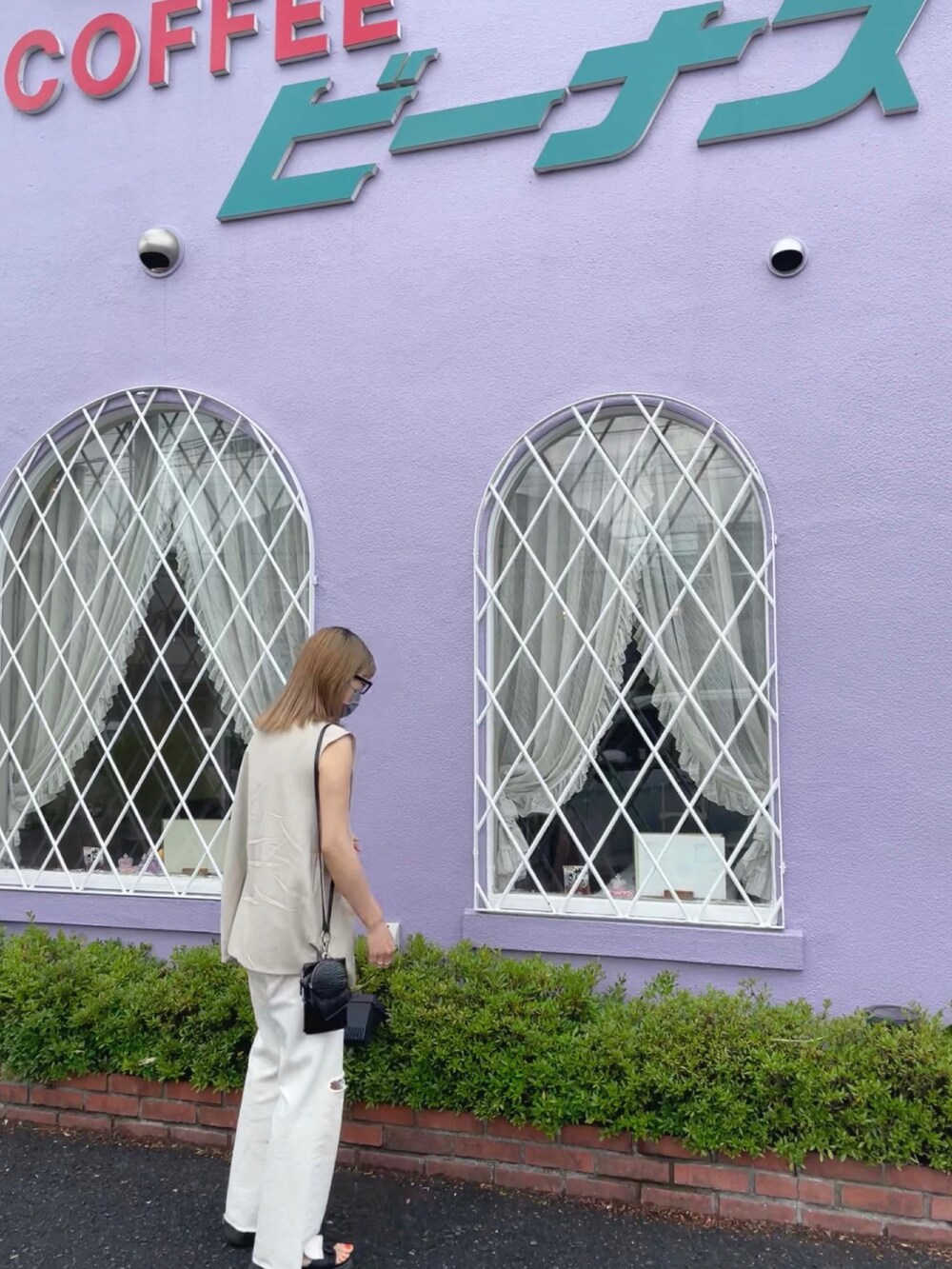 ブラック系のキャミソール、ベージュ系のベスト、ホワイト系のデニムパンツを着用したレディースの夏コーディネートの2枚目の写真