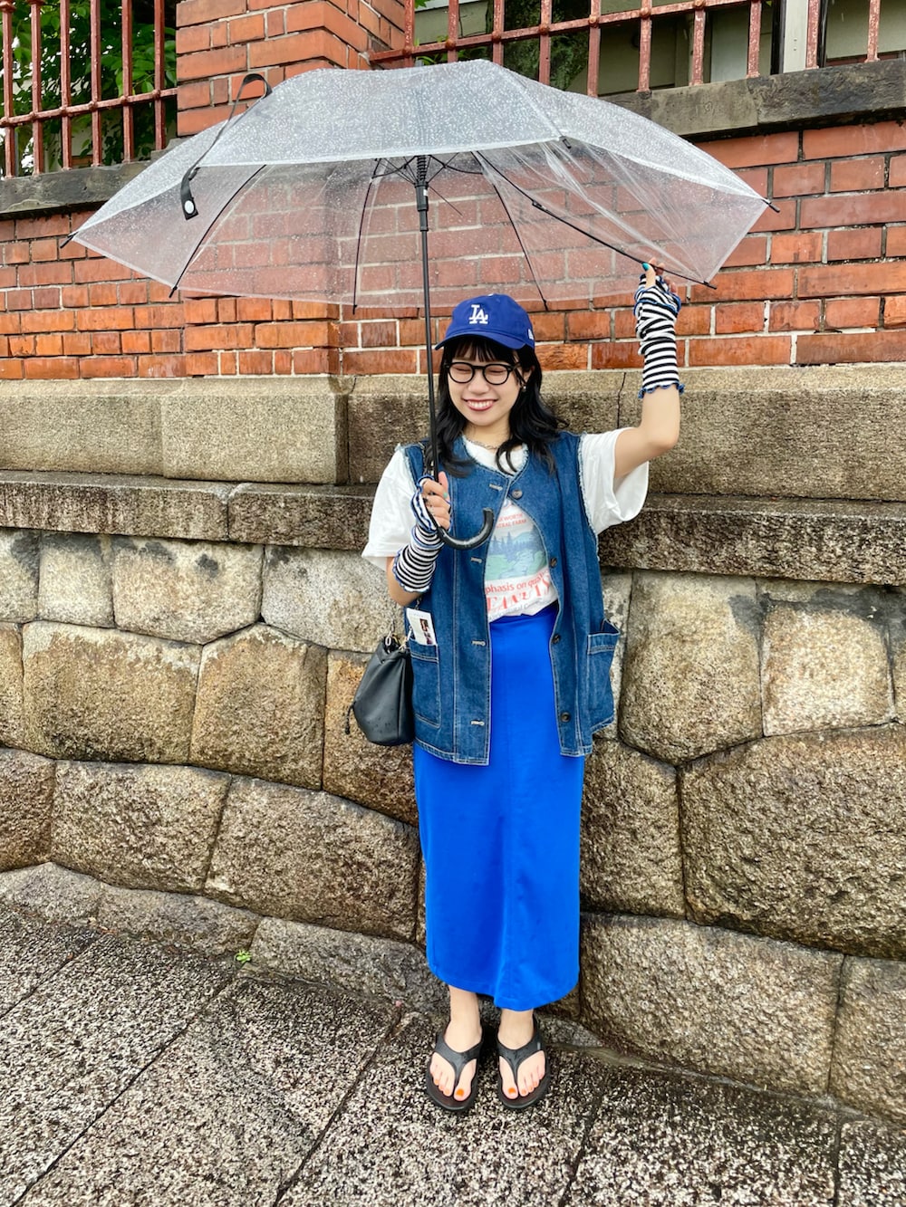 「夏のコスメと服、今日のコスメと服、夏コーデ、カジュアルコーデ、カラーコーデ、カラースカート、ブルーコーデ、キャップ、Tシャツ、デニムベスト、ダテメガネ、oofos、アームウォーマー、ゆったりコーデ、お洒落さんとつながりたい」｜「DISCOATのCamBridgeスーベニアビックTシャツ（Tシャツ/カットソー、ホワイト系）」を使った、ponさん（レディース・163cm）の夏コーディネートの3枚目の写真