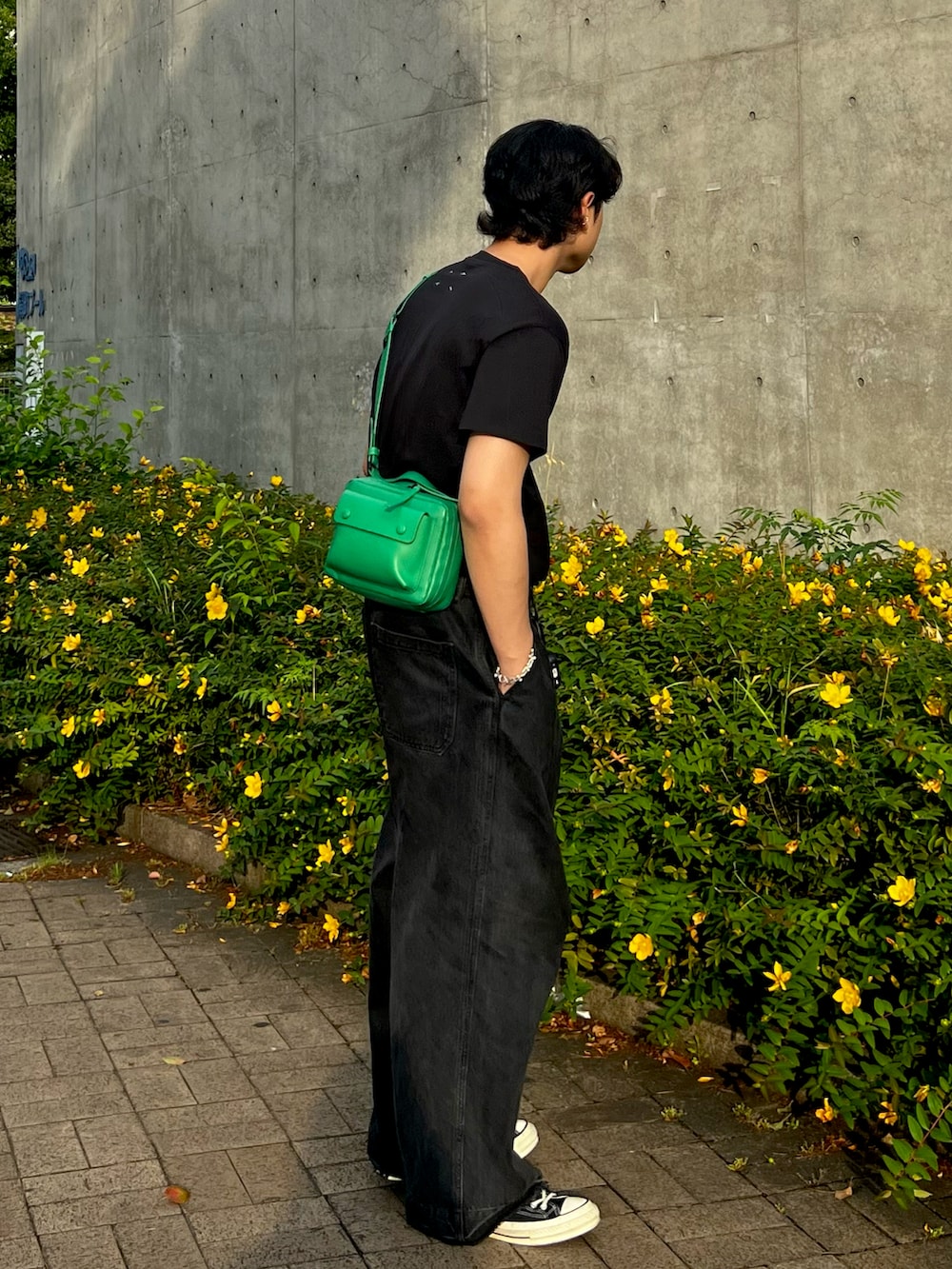 ブラック系のスニーカー、ブラック系のデニムパンツ、ブラック系のTシャツ/カットソーを着用したメンズの夏コーディネートの2枚目の写真