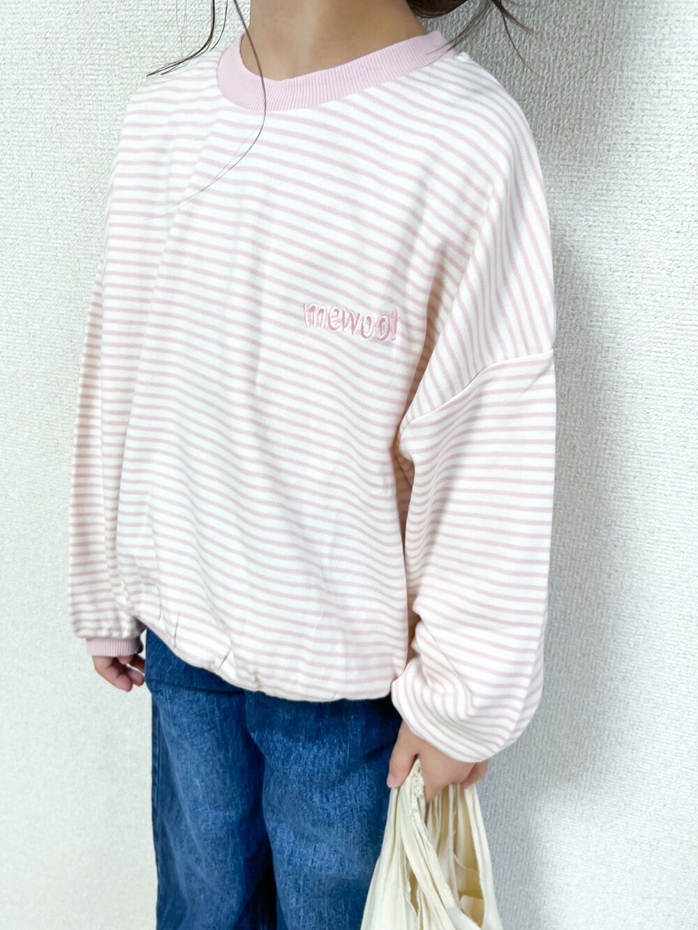 ピンク系のスウェット、ブルー系のデニムパンツ、ピンク系のスニーカーを着用したキッズの秋コーディネートの4枚目の写真