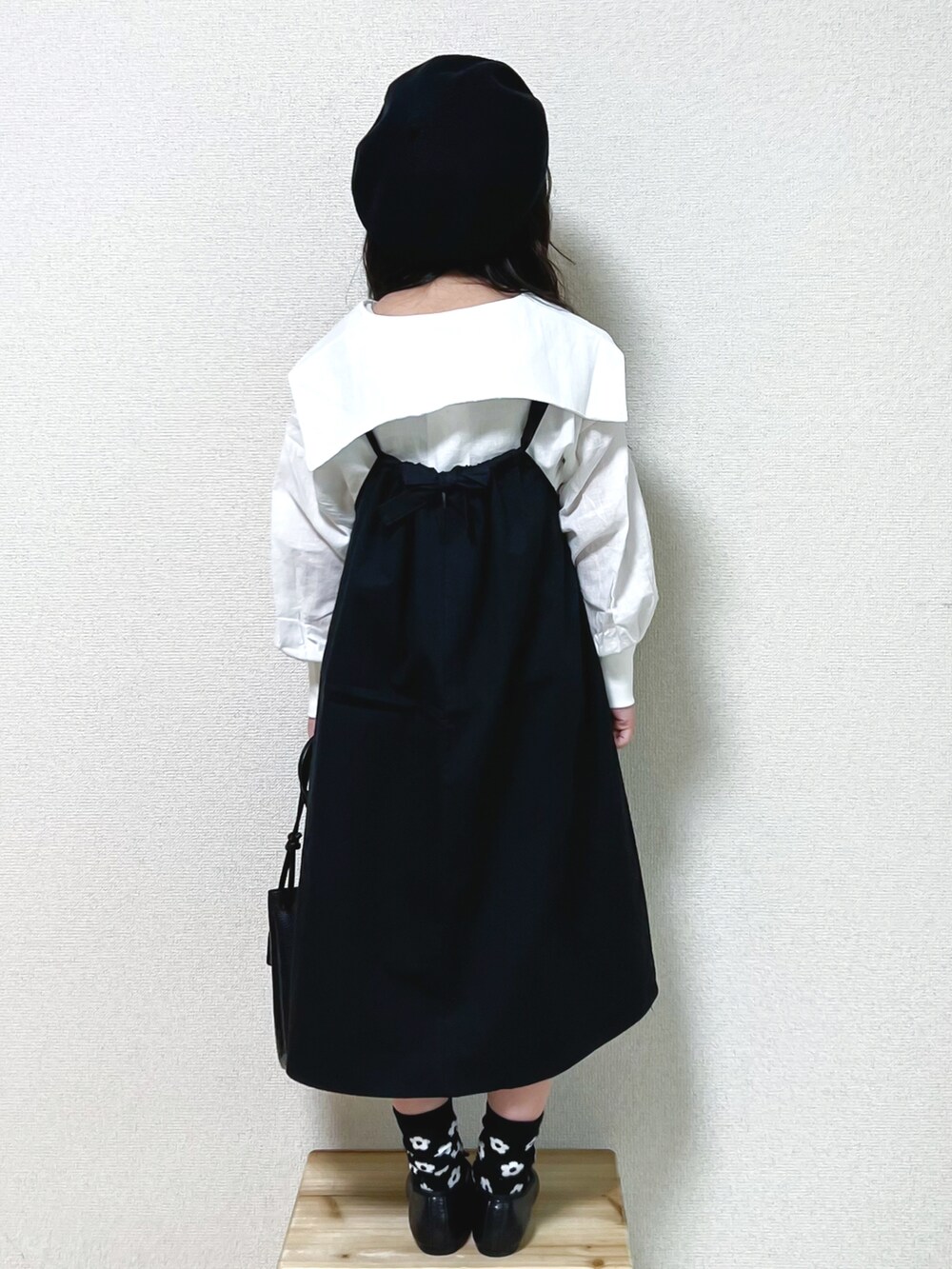 ホワイト系のシャツ/ブラウス、ブラック系のシャツワンピース、ブラック系のバレエシューズを着用したキッズの春コーディネートの3枚目の写真