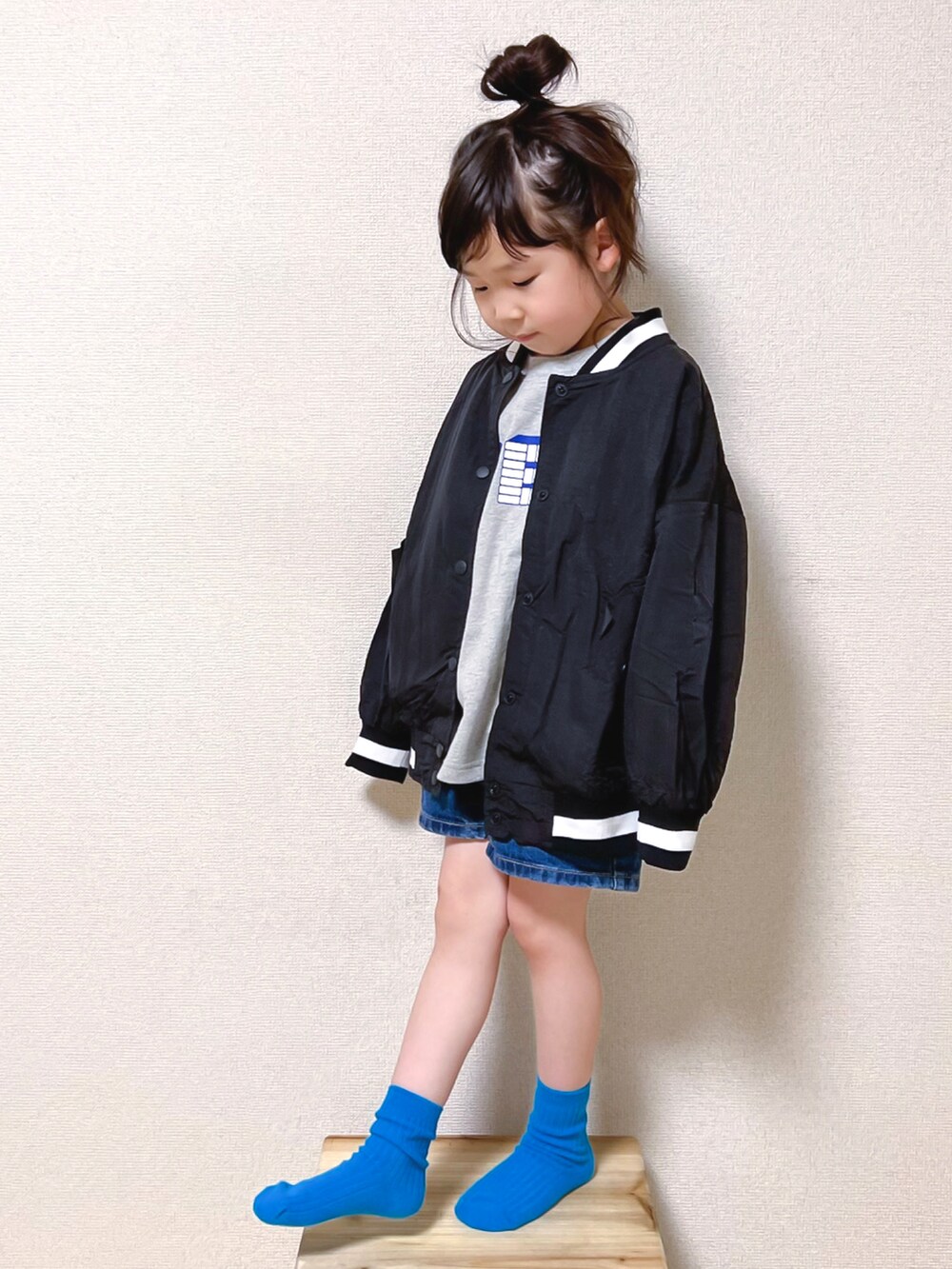 グレー系のTシャツ/カットソー、ブルー系のデニムパンツ、ブラック系のスタジャンを着用したキッズの春コーディネートの4枚目の写真