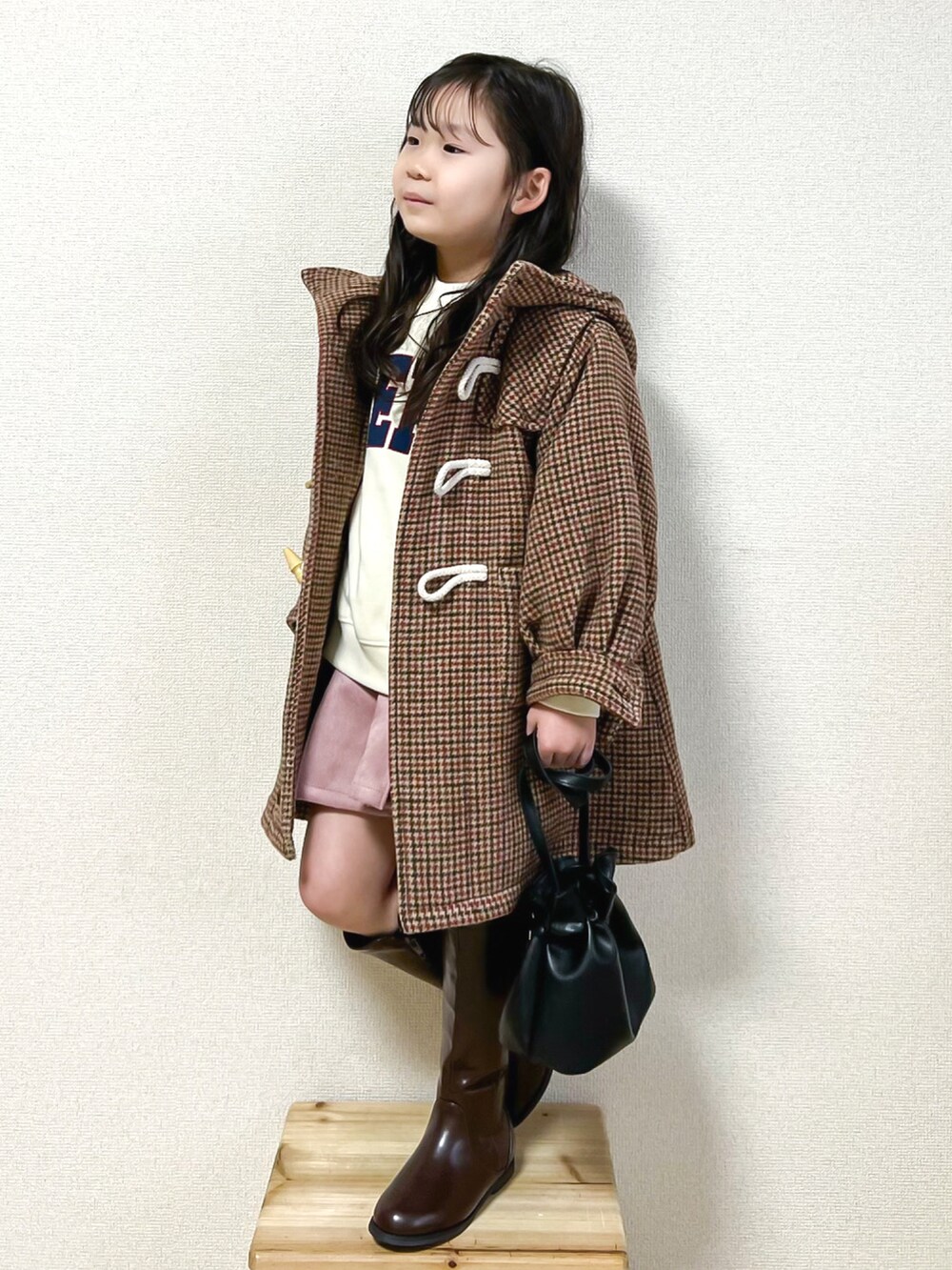 ブラウン系のダッフルコート、ホワイト系のスウェット、ピンク系のその他パンツを着用したキッズの冬コーディネートの3枚目の写真