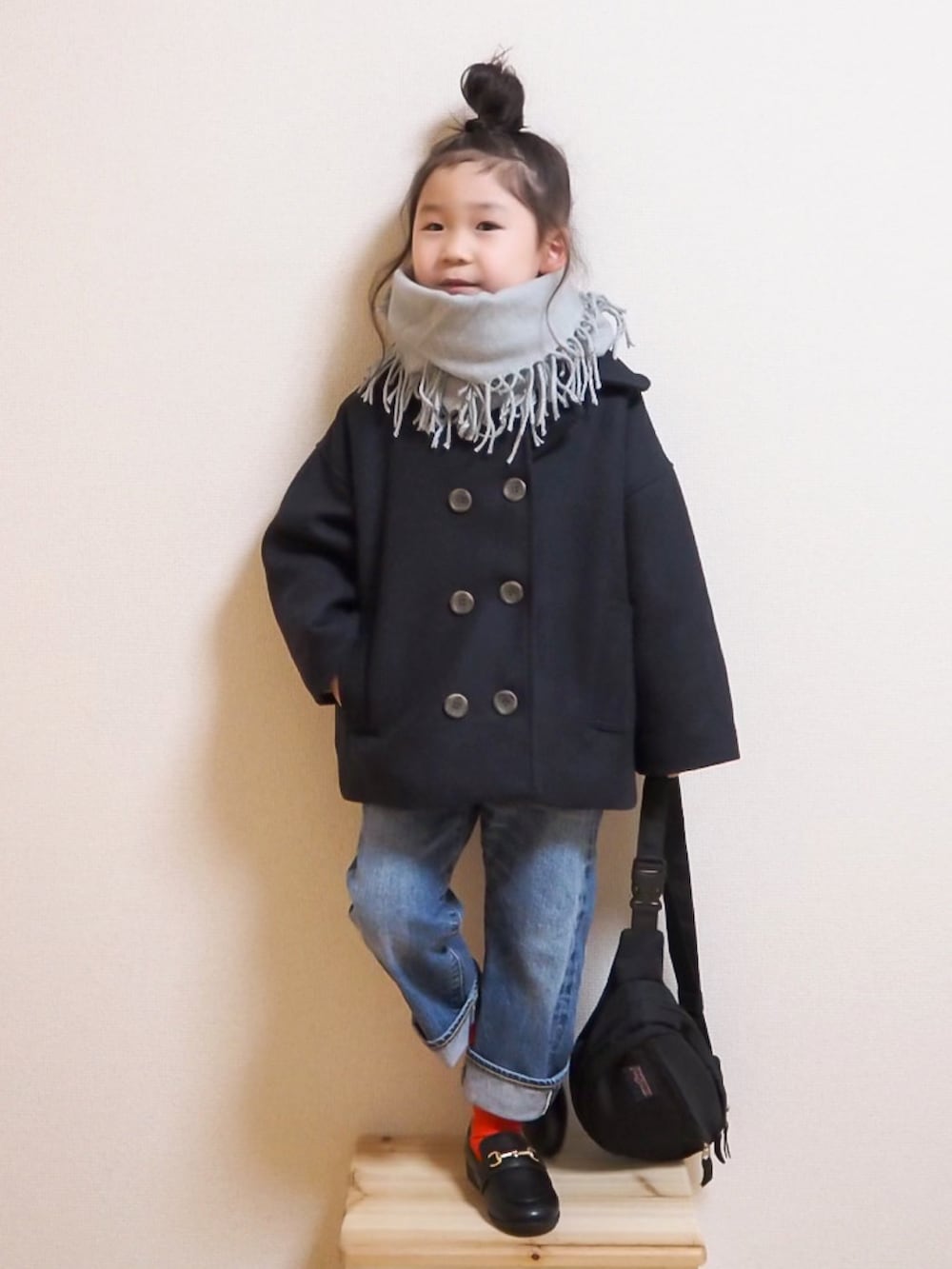 ブルー系のピーコート、ブルー系のデニムパンツ、ブラック系のローファーを着用したキッズの冬コーディネートの2枚目の写真