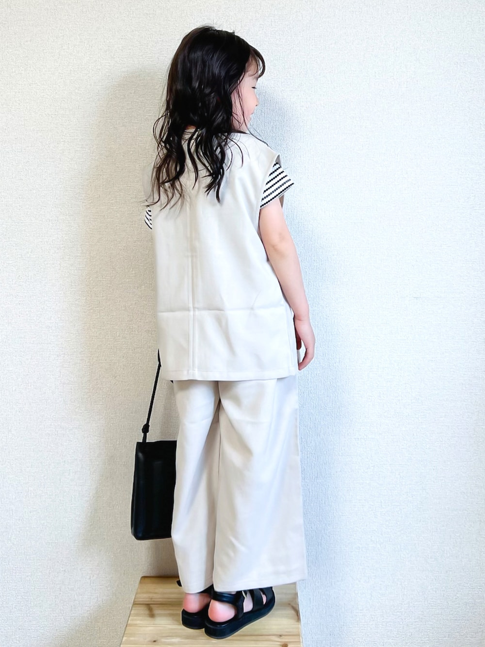 ブラック系のTシャツ/カットソー、ホワイト系のベスト、ホワイト系のその他パンツを着用したキッズの春コーディネートの2枚目の写真