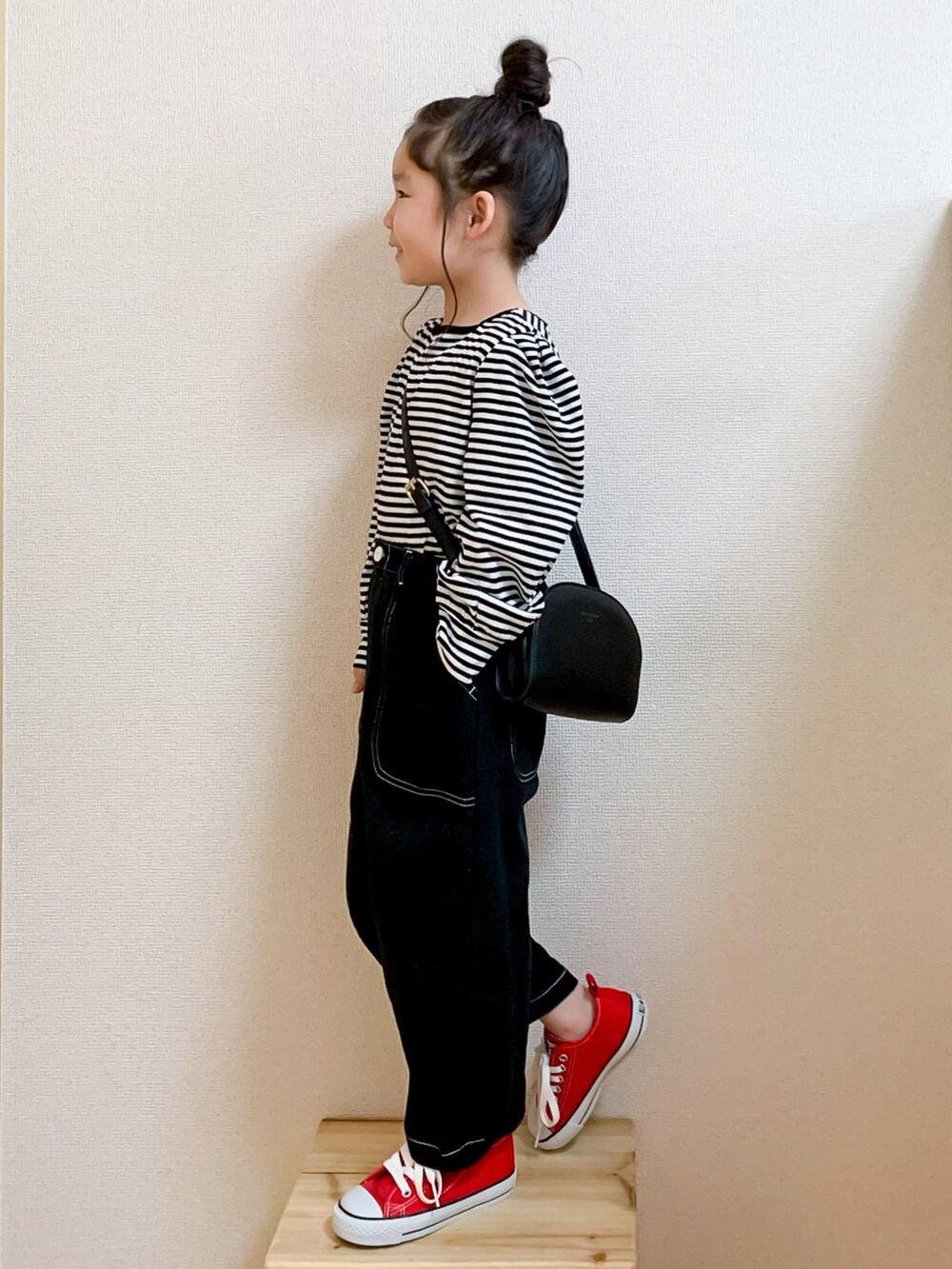 イエロー系のトレンチコート、ブラック系のTシャツ/カットソー、ブラック系のその他パンツを着用したキッズの春コーディネートの4枚目の写真