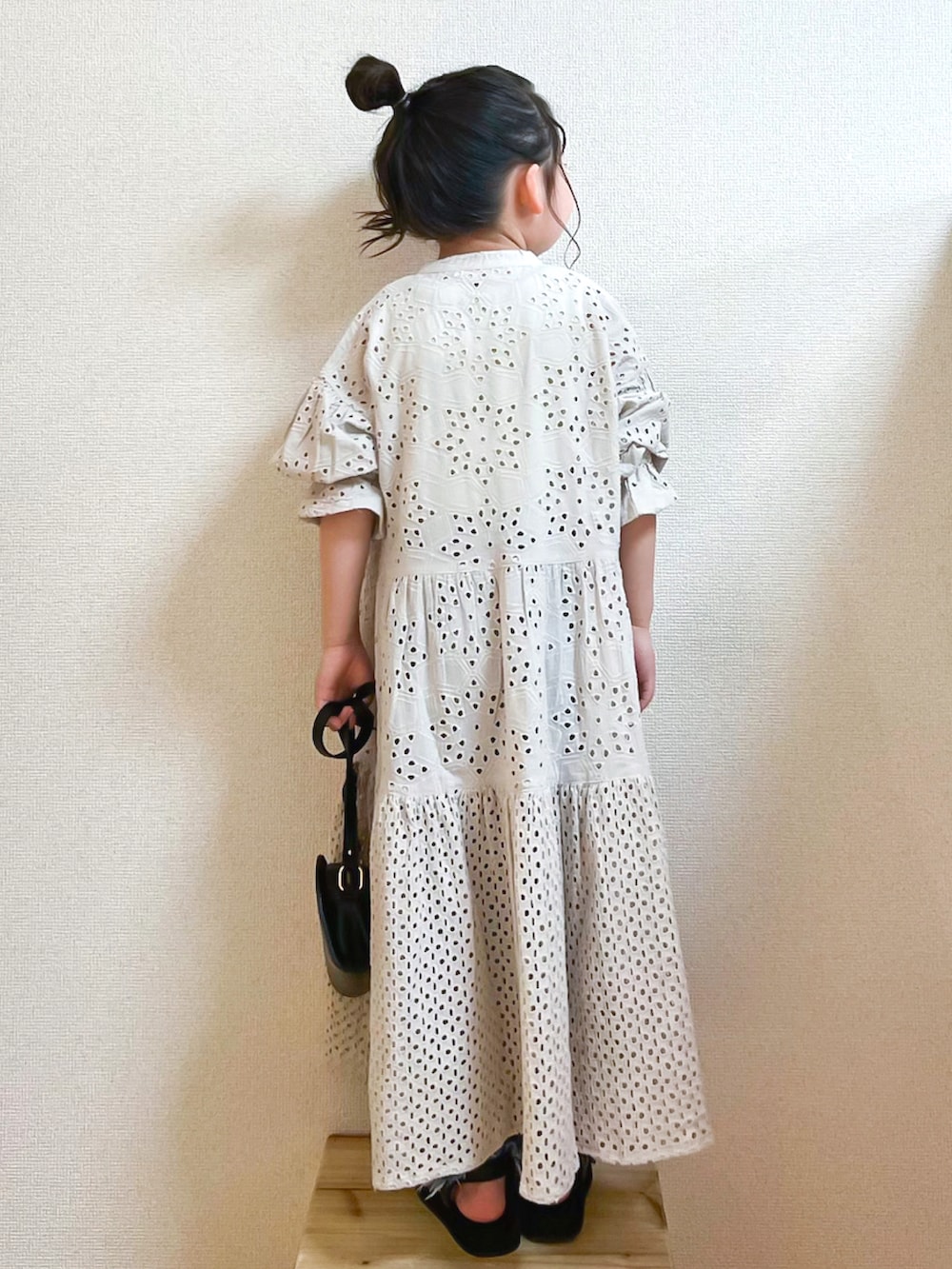 グレー系のワンピース、イエロー系のタンクトップ、ブルー系のデニムパンツを着用したキッズの春コーディネートの2枚目の写真