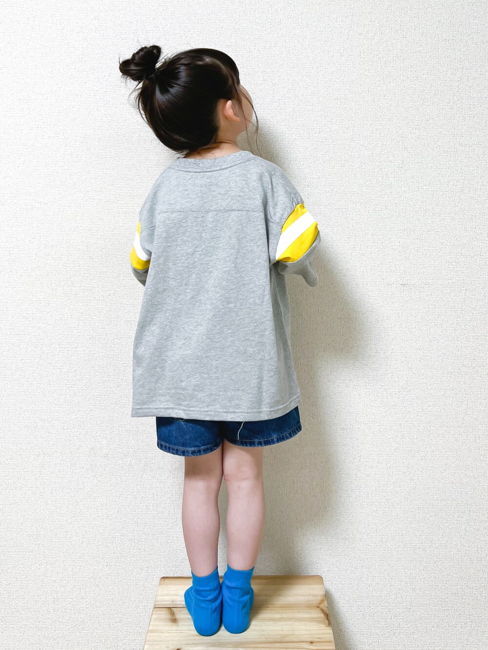 グレー系のTシャツ/カットソー、ブルー系のデニムパンツ、ブラック系のスタジャンを着用したキッズの春コーディネートの2枚目の写真