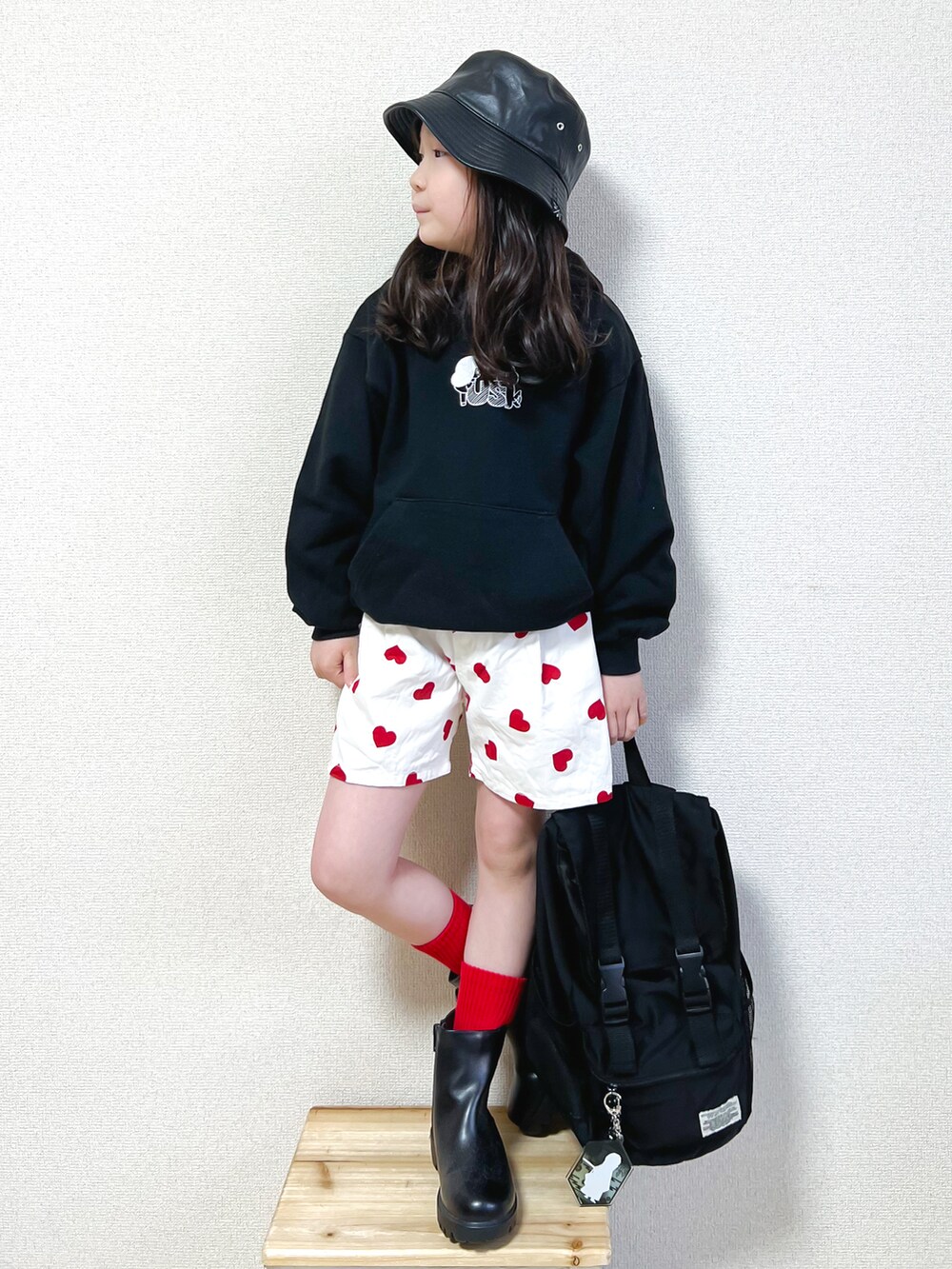 ブラック系のパーカー、レッド系のその他パンツ、ブラック系のブーツを着用したキッズの春コーディネートの2枚目の写真