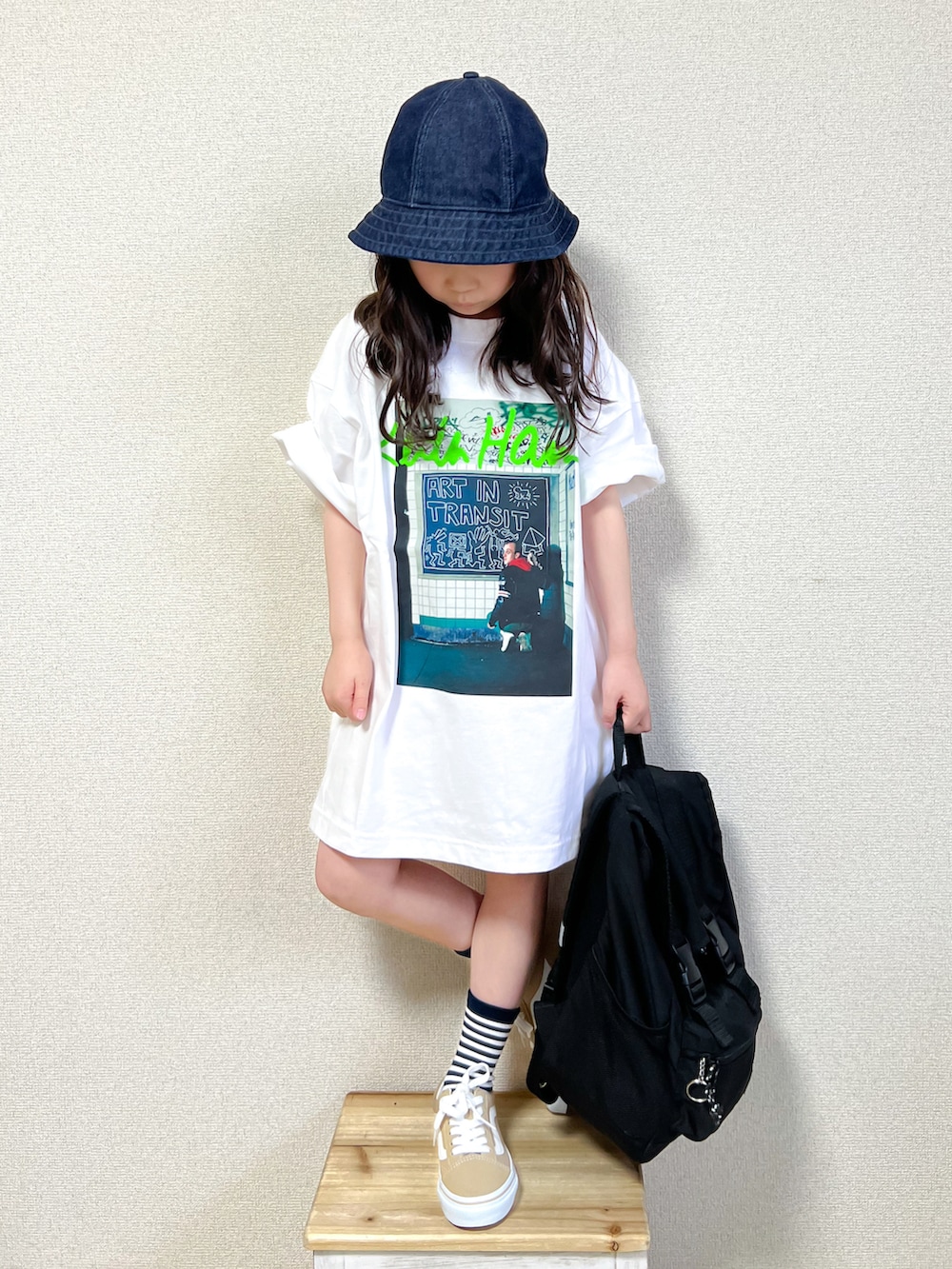ホワイト系のTシャツ/カットソー、ベージュ系のスニーカー、ブラック系のバックパック/リュックを着用したキッズの春コーディネートの3枚目の写真