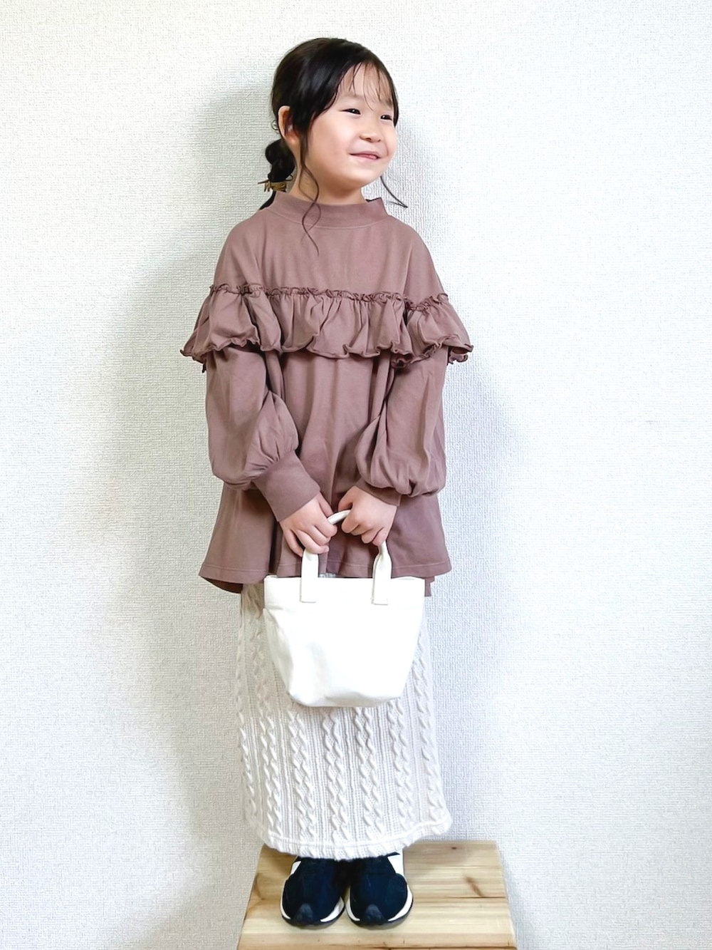 グレー系のTシャツ/カットソー、ホワイト系のスカート、ブラック系のスニーカーを着用したキッズの秋コーディネートの2枚目の写真