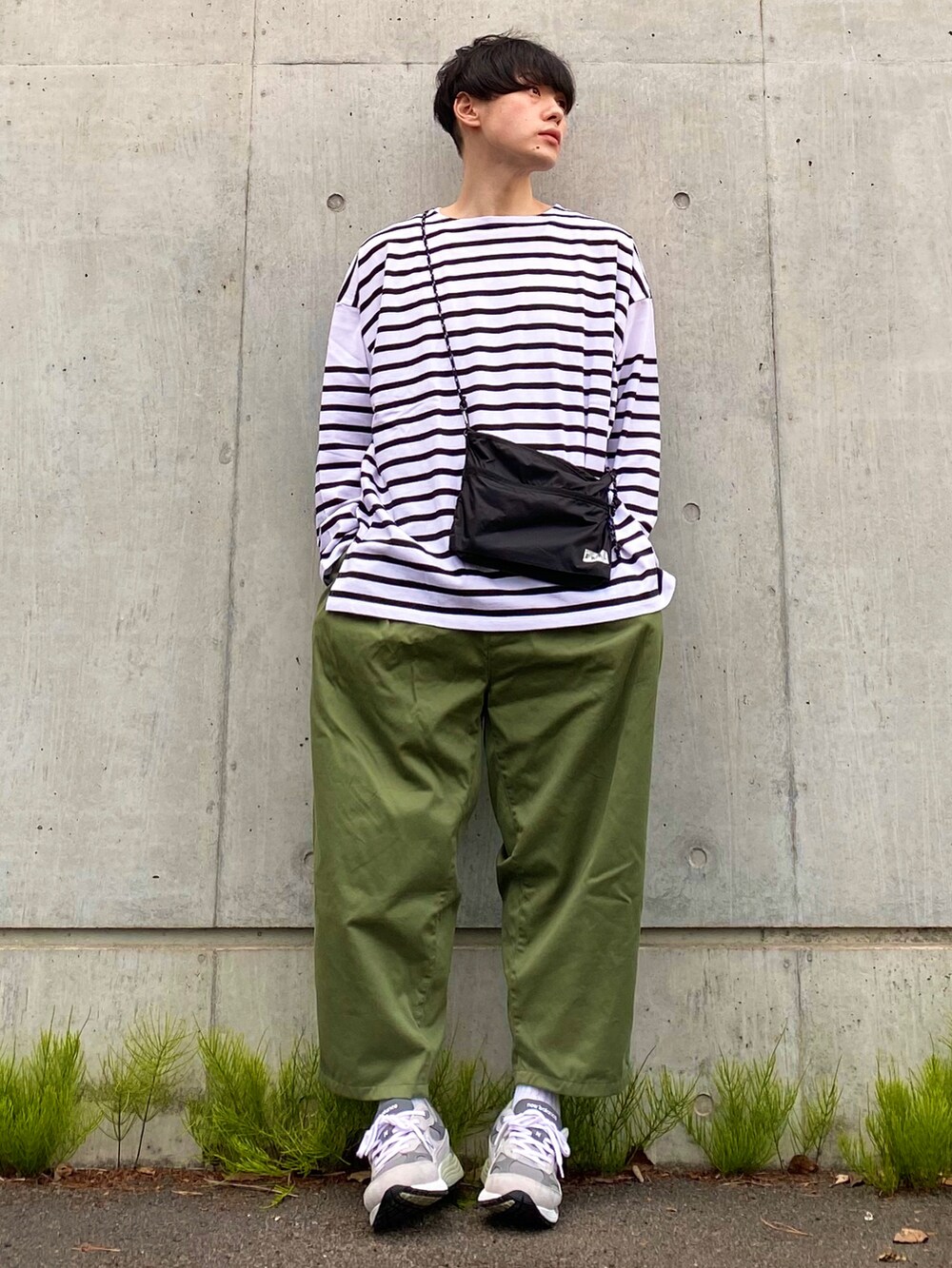 ブラック系のTシャツ/カットソー、ブラック系のショルダーバッグ、グリーン系のその他パンツを着用したメンズの春コーディネートの2枚目の写真