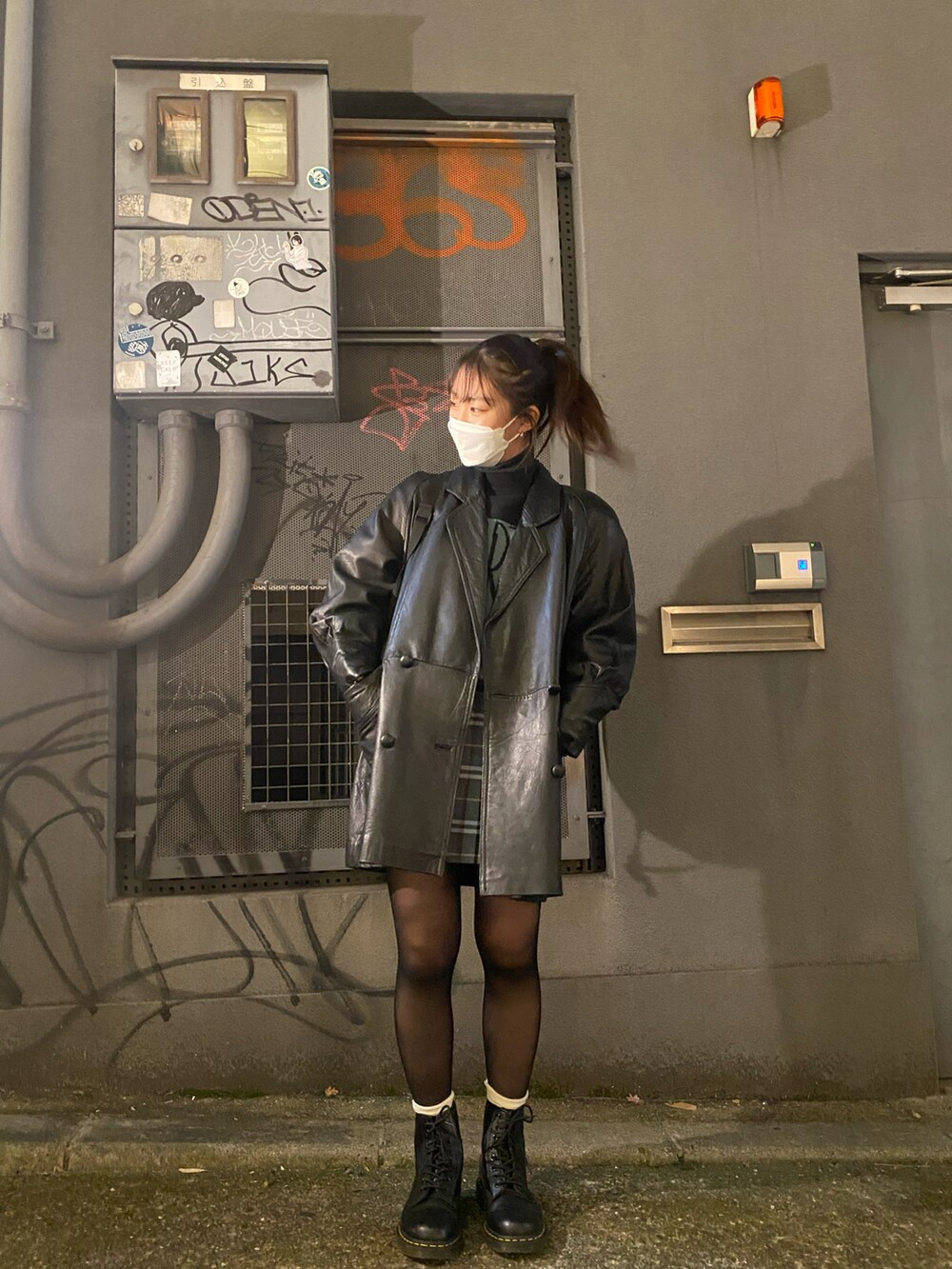 ブラック系のブーツ、ブルー系のスカート、ブラック系のニット/セーターを着用したレディースの冬コーディネートの2枚目の写真