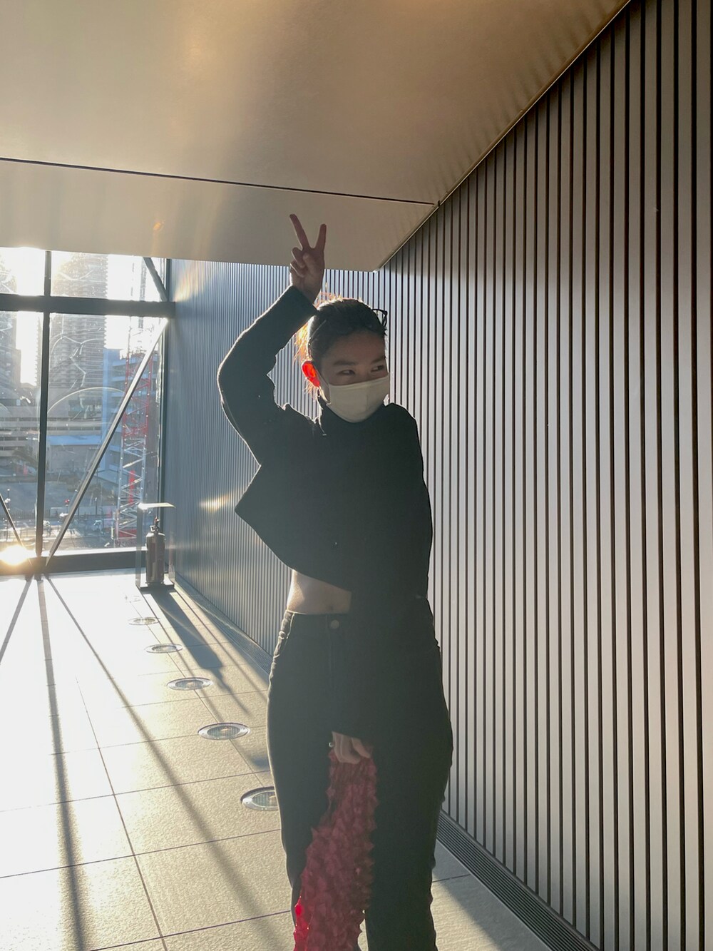 ブラック系のパンツ、ブラック系のスニーカー、レッド系のバッグを着用したレディースの冬コーディネートの2枚目の写真