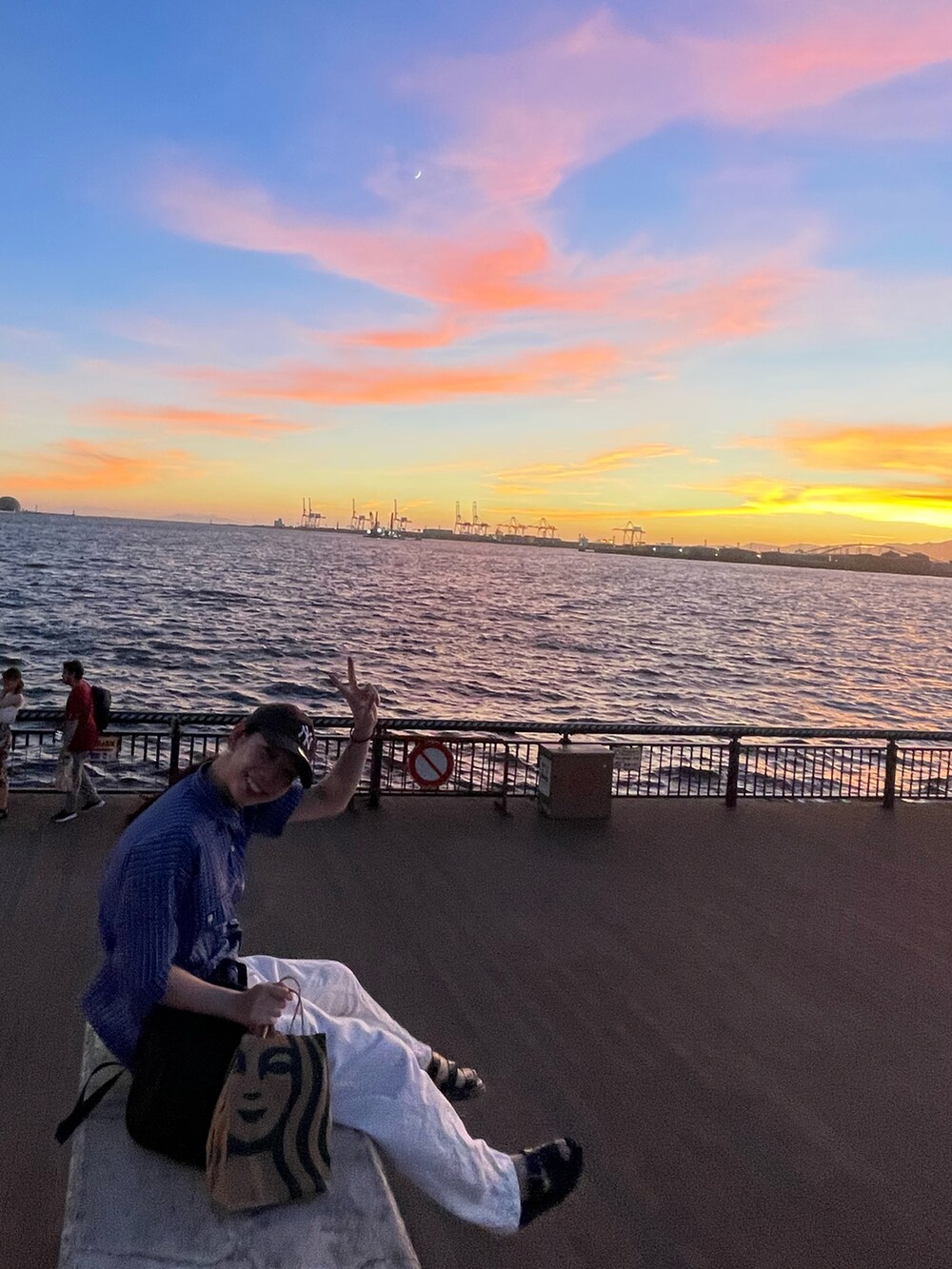 ブルー系のシャツ/ブラウス、ホワイト系のパンツ、ブラック系のサンダルを着用したレディースの夏コーディネートの2枚目の写真