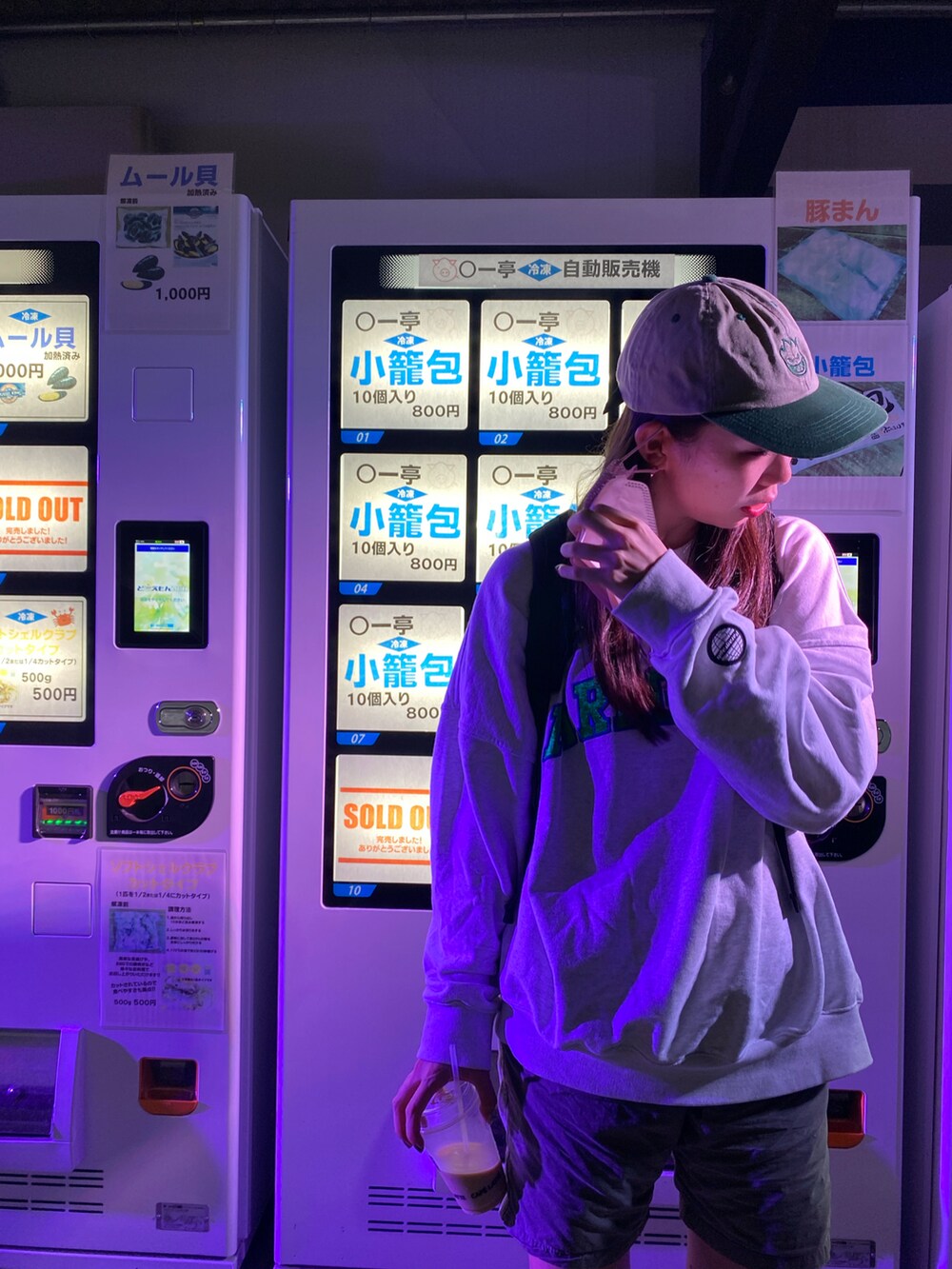 グレー系のスウェット、グリーン系のキャップを着用したレディースの秋コーディネートの2枚目の写真