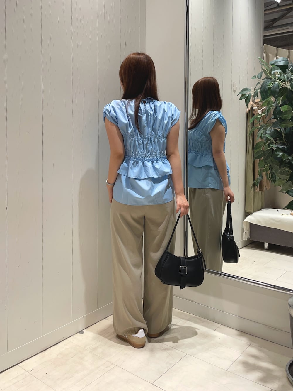 ブルー系のシャツ/ブラウス、ベージュ系のスラックス、ブラック系のボストンバッグを着用したレディースの夏コーディネートの2枚目の写真