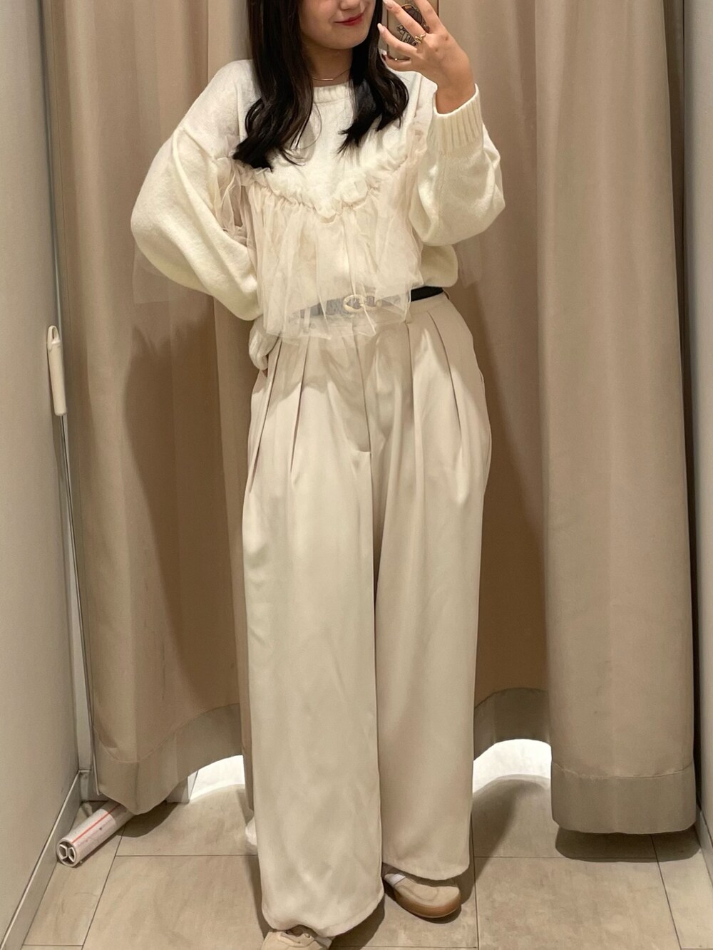 ホワイト系のニット/セーター、ホワイト系のスラックス、ブラック系のベルトを着用したレディースの秋コーディネートの4枚目の写真