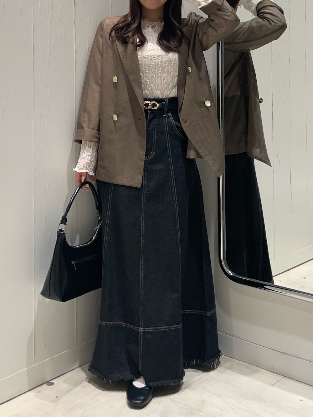 ブラック系のスカート、ホワイト系のTシャツ/カットソー、ブラウン系のテーラードジャケットを着用したレディースの秋コーディネートの4枚目の写真