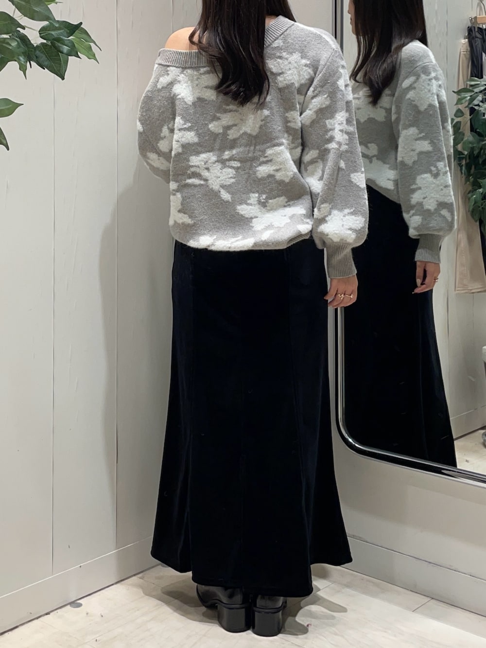 グレー系のニット/セーター、ブラック系のスカート、ブラック系のブーツを着用したレディースの秋コーディネートの3枚目の写真