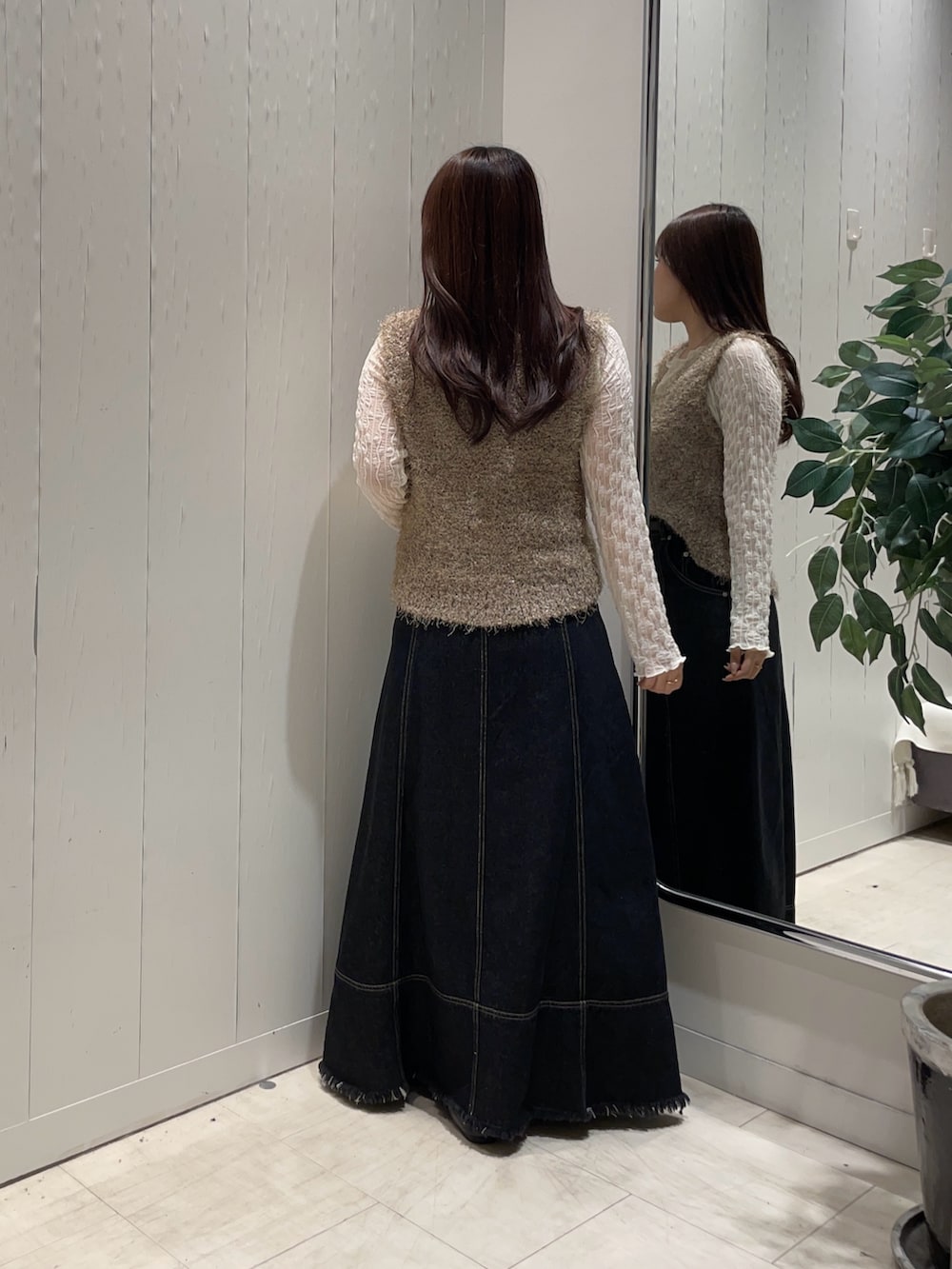 ベージュ系のニット/セーター、ホワイト系のTシャツ/カットソー、ブラック系のスカートを着用したレディースの秋コーディネートの2枚目の写真