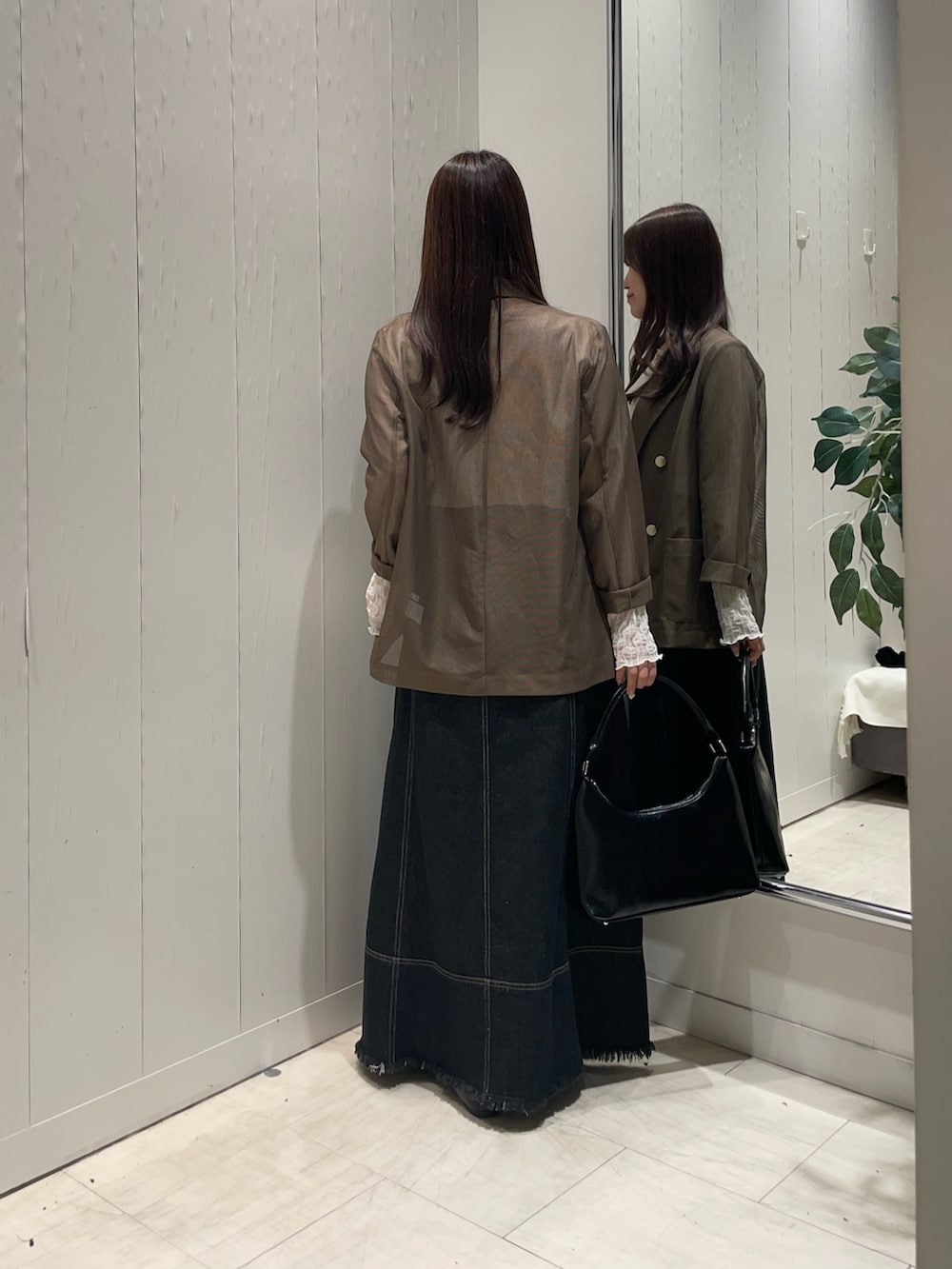 ブラック系のスカート、ホワイト系のTシャツ/カットソー、ブラウン系のテーラードジャケットを着用したレディースの秋コーディネートの3枚目の写真