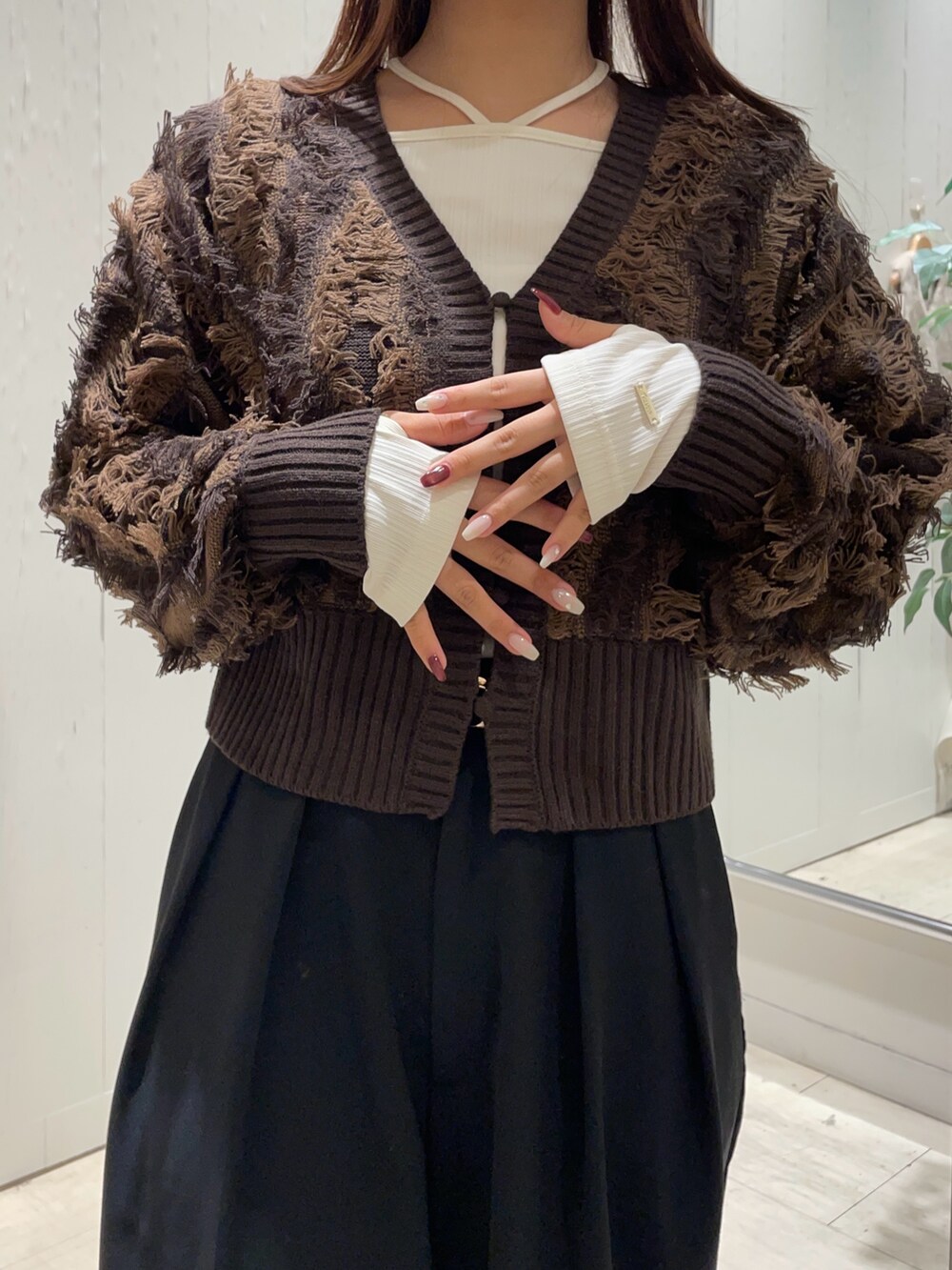 ブラック系のスラックス、ブラック系のパンプス、ブラウン系のカーディガン/ボレロを着用したレディースの秋コーディネートの2枚目の写真