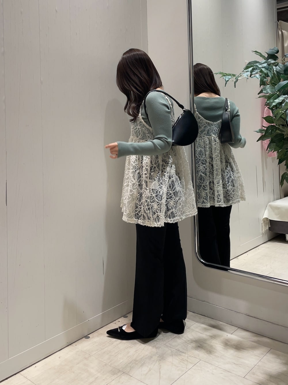 ホワイト系のチュニック、グリーン系のニット/セーター、ブラック系のその他パンツを着用したレディースの冬コーディネートの2枚目の写真