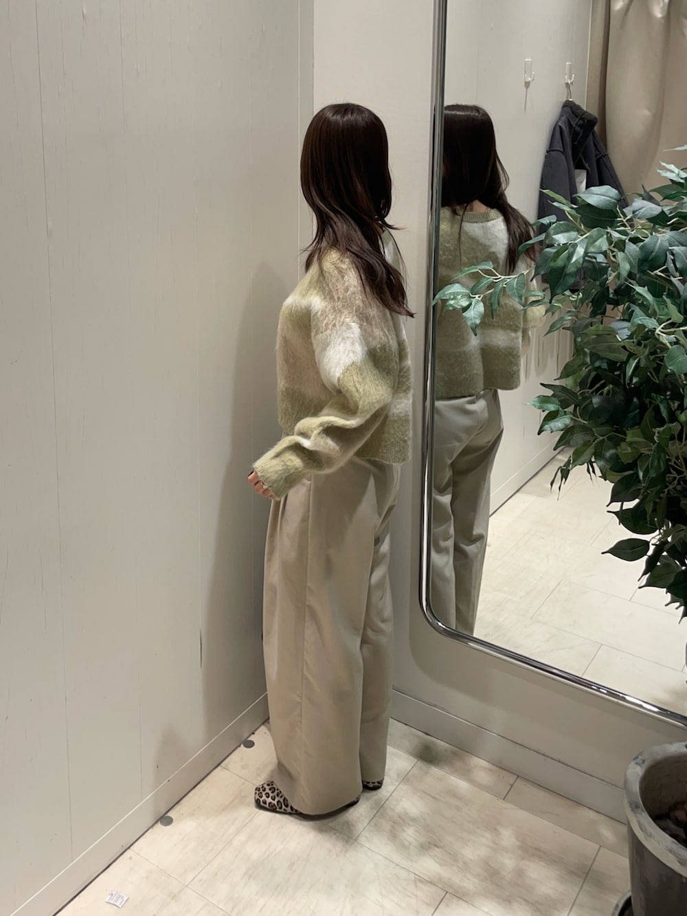 グリーン系のニット/セーターを着用したレディースの冬コーディネートの2枚目の写真