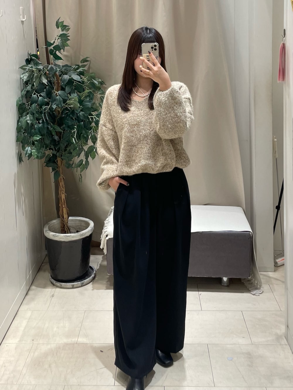 ベージュ系のニット/セーター、ブラック系のスラックスを着用したレディースの冬コーディネートの2枚目の写真