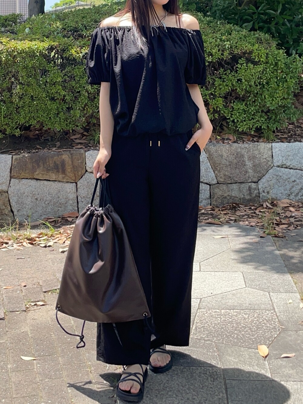 ブラック系のつなぎ/オールインワン、ブラウン系のバックパック/リュックを着用したレディースの夏コーディネートの4枚目の写真