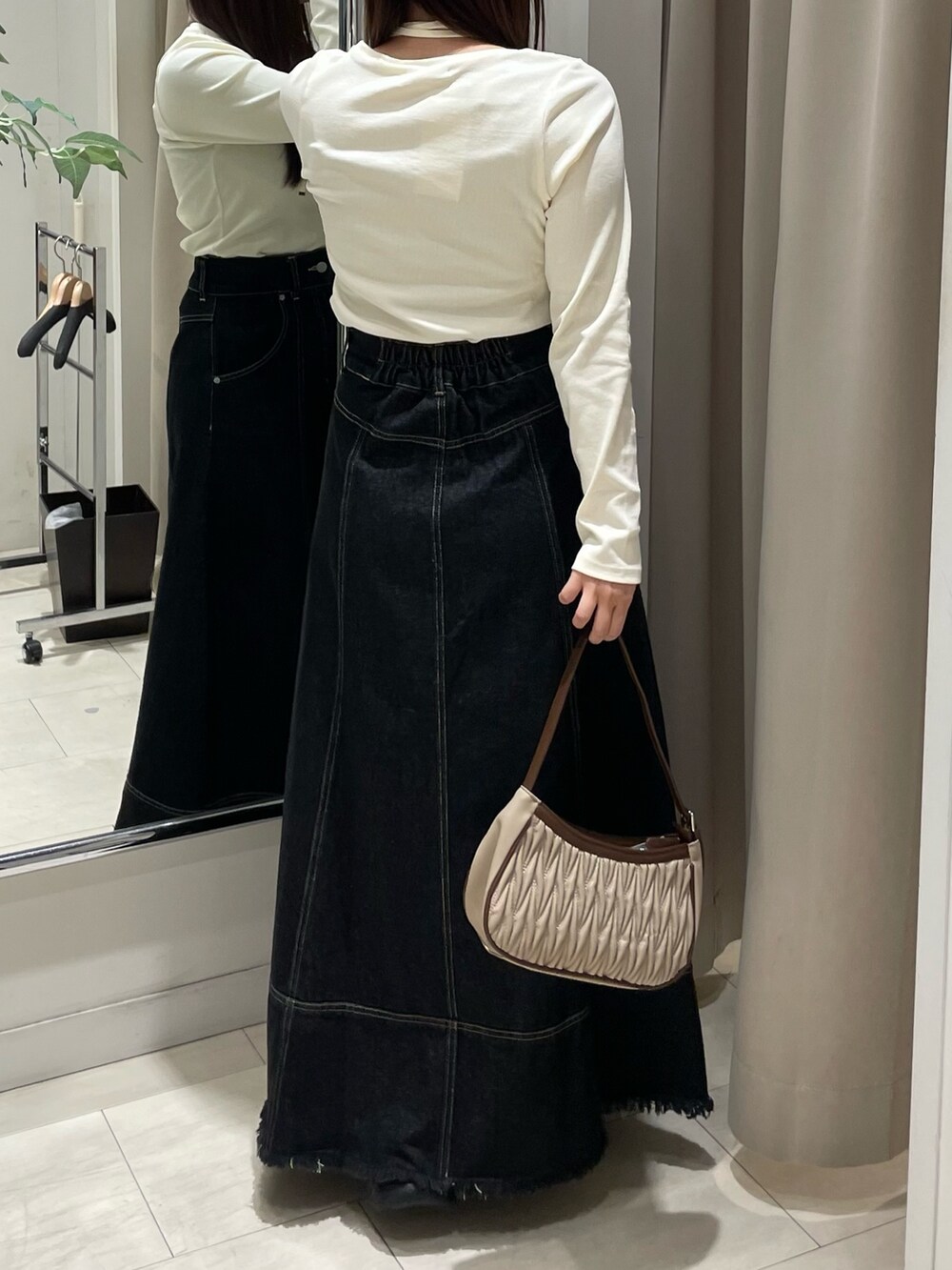 ブラック系のスカート、ホワイト系のTシャツ/カットソーを着用したレディースの秋コーディネートの3枚目の写真