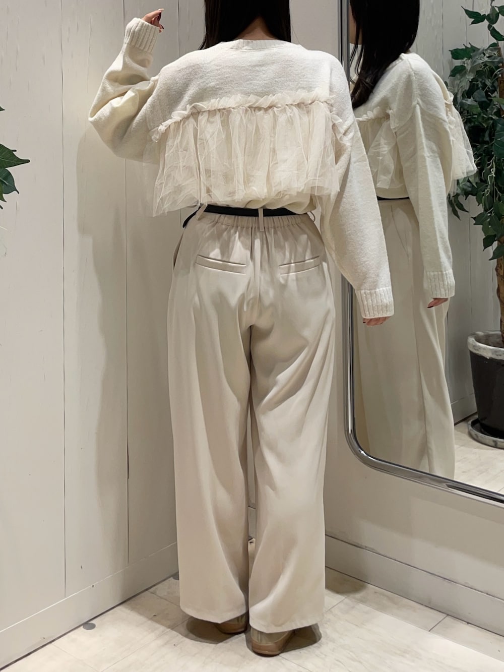 ホワイト系のニット/セーター、ホワイト系のスラックス、ブラック系のベルトを着用したレディースの秋コーディネートの3枚目の写真