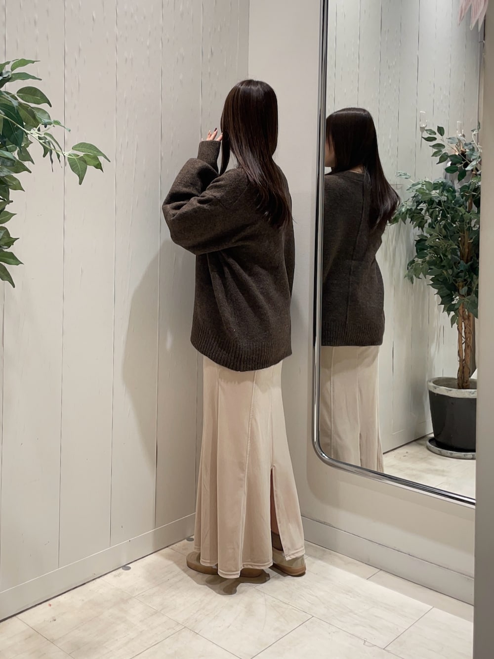 ホワイト系のスカート、ベージュ系のTシャツ/カットソー、ブラウン系のカーディガン/ボレロを着用したレディースの秋コーディネートの2枚目の写真
