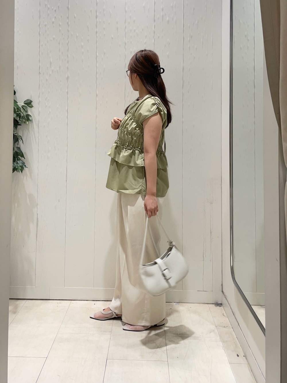 グリーン系のシャツ/ブラウス、ホワイト系のスラックス、ホワイト系のサンダルを着用したレディースの夏コーディネートの3枚目の写真