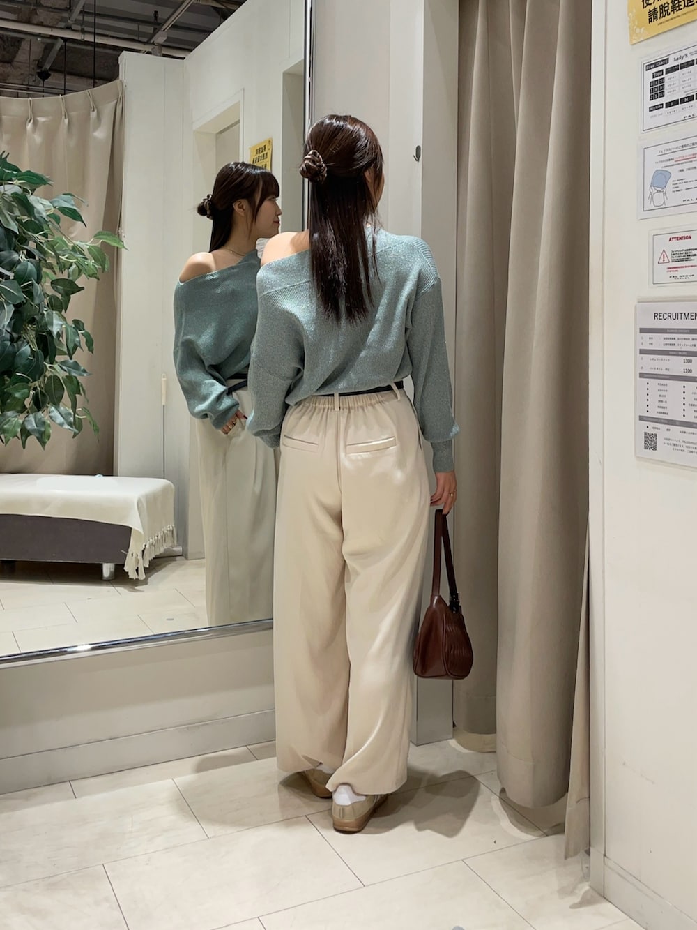 グリーン系のニット/セーター、ホワイト系のスラックス、ブラック系のベルトを着用したレディースの秋コーディネートの2枚目の写真