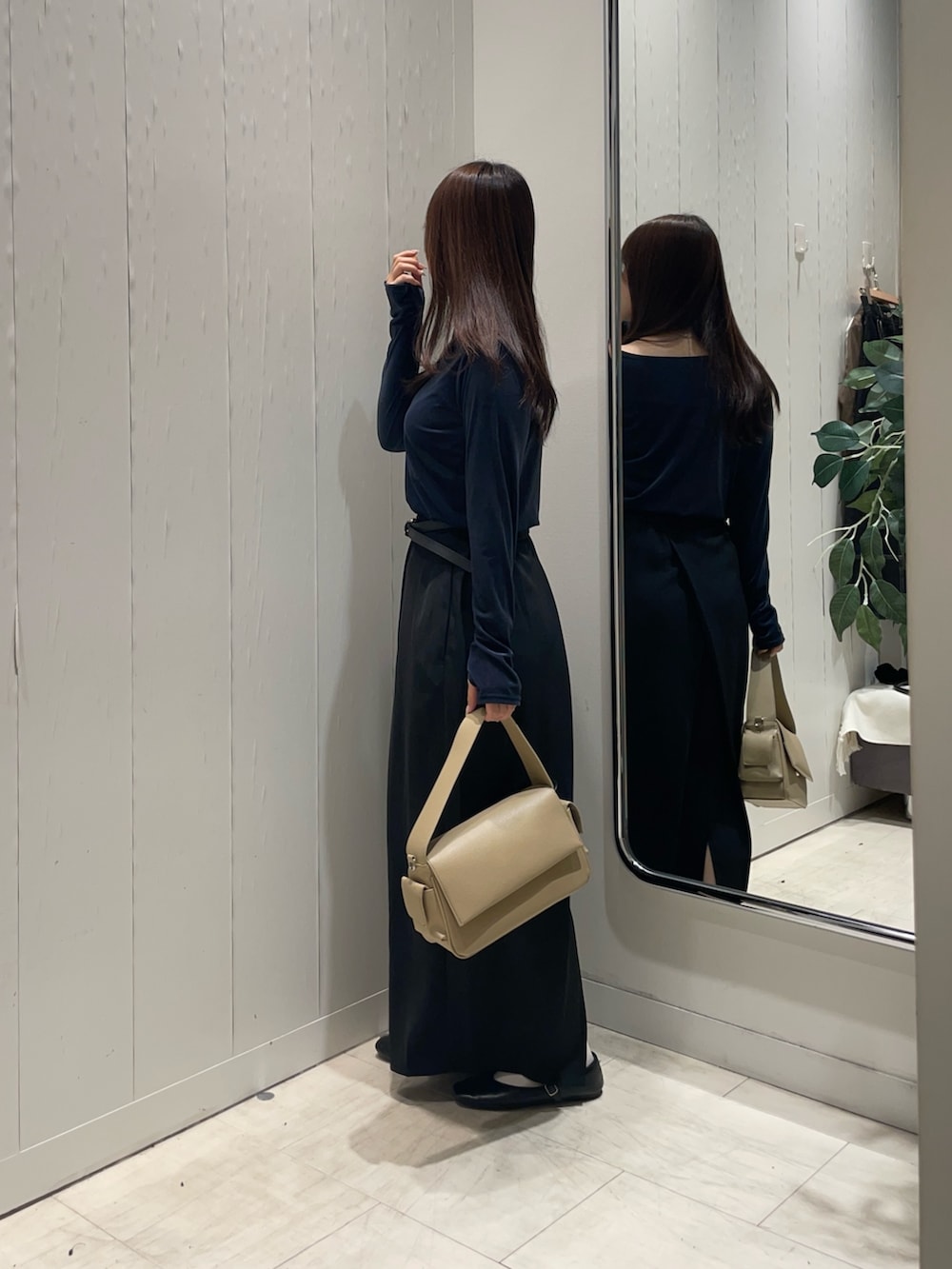 ブルー系のTシャツ/カットソー、ブラック系のスカート、ベージュ系のボストンバッグを着用したレディースの秋コーディネートの2枚目の写真
