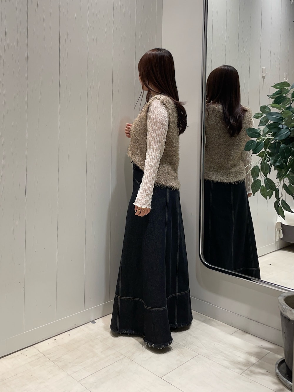 ベージュ系のニット/セーター、ホワイト系のTシャツ/カットソー、ブラック系のスカートを着用したレディースの秋コーディネートの3枚目の写真