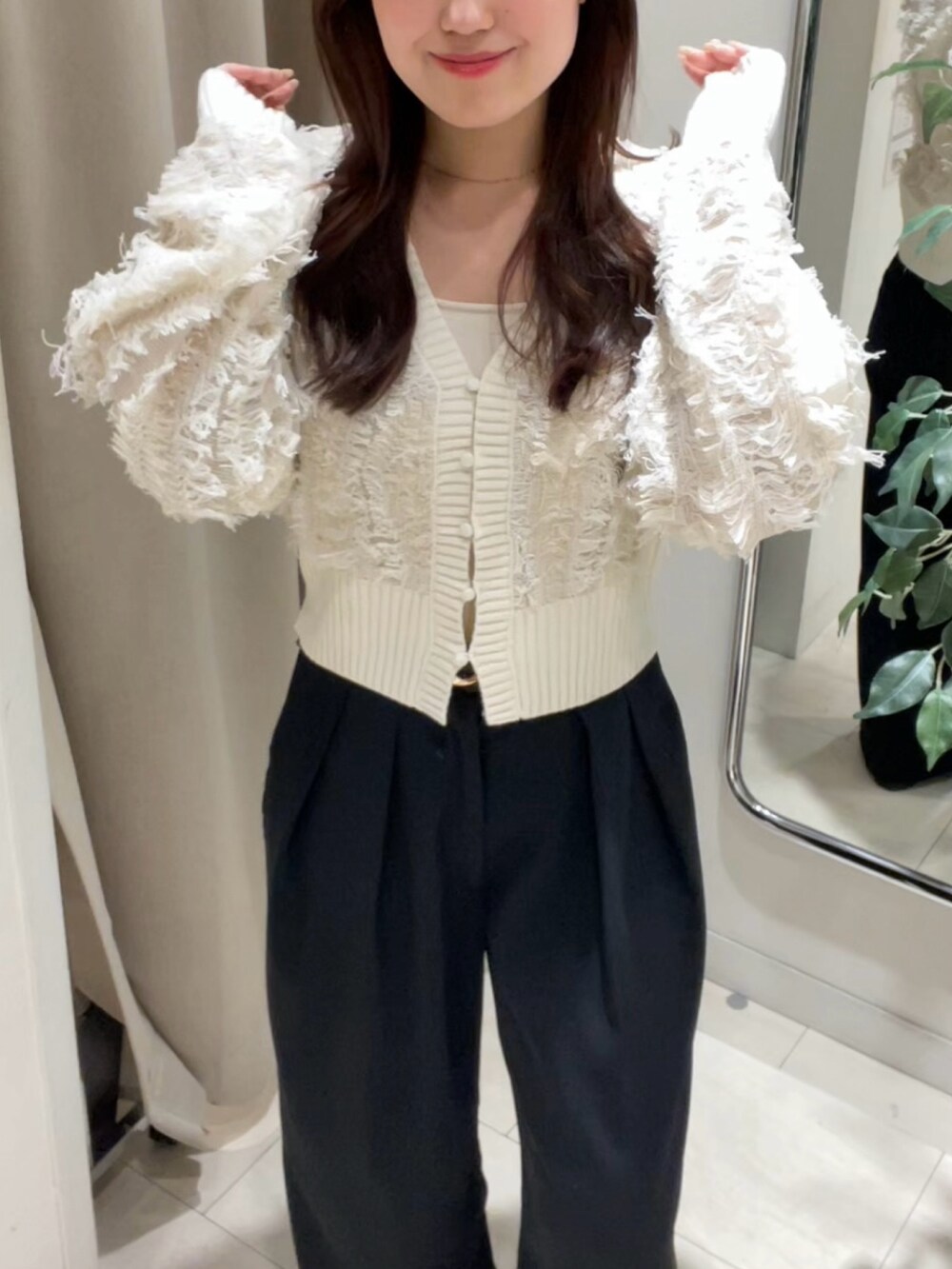 ホワイト系のカーディガン/ボレロ、ブラック系のスラックス、ブラック系のベルトを着用したレディースの秋コーディネートの3枚目の写真