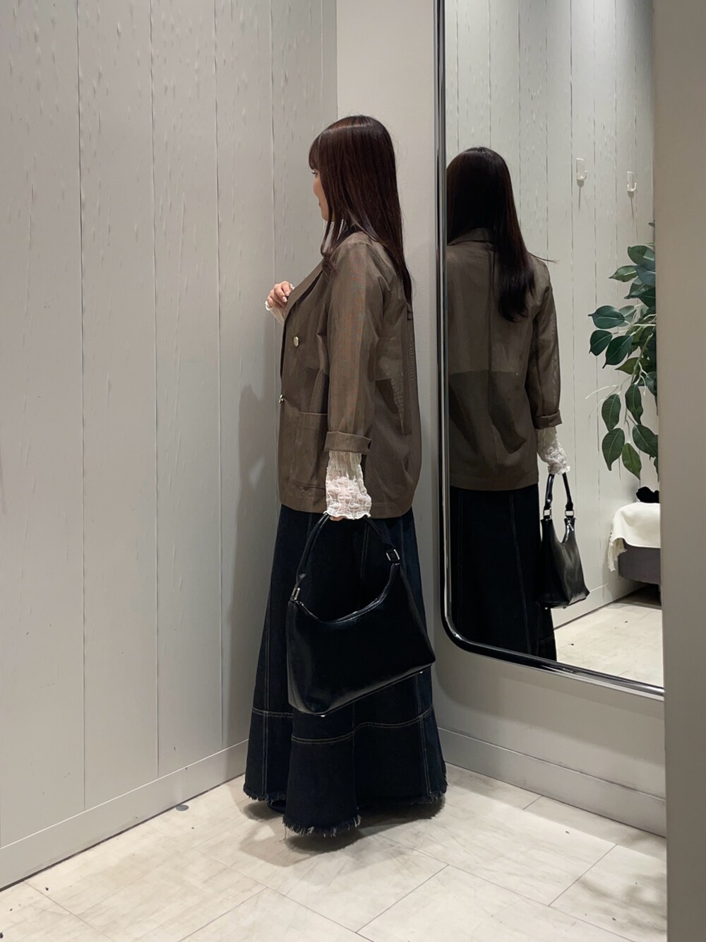 ブラック系のスカート、ホワイト系のTシャツ/カットソー、ブラウン系のテーラードジャケットを着用したレディースの秋コーディネートの2枚目の写真