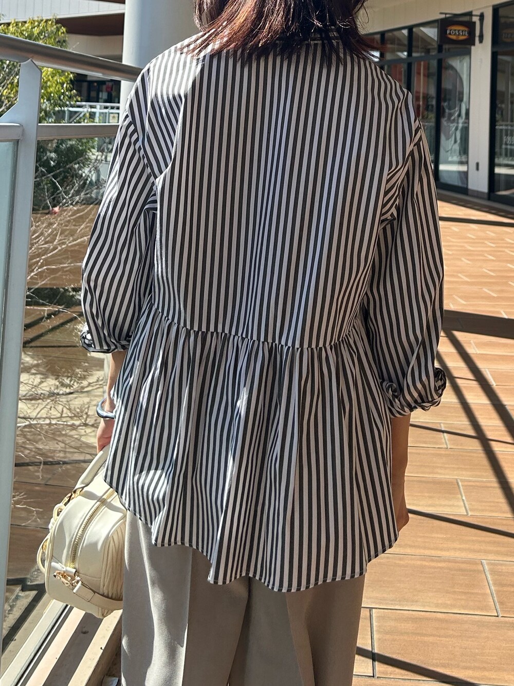 ベージュ系のその他パンツ、グレー系のシャツ/ブラウスを着用したレディースの春コーディネートの6枚目の写真