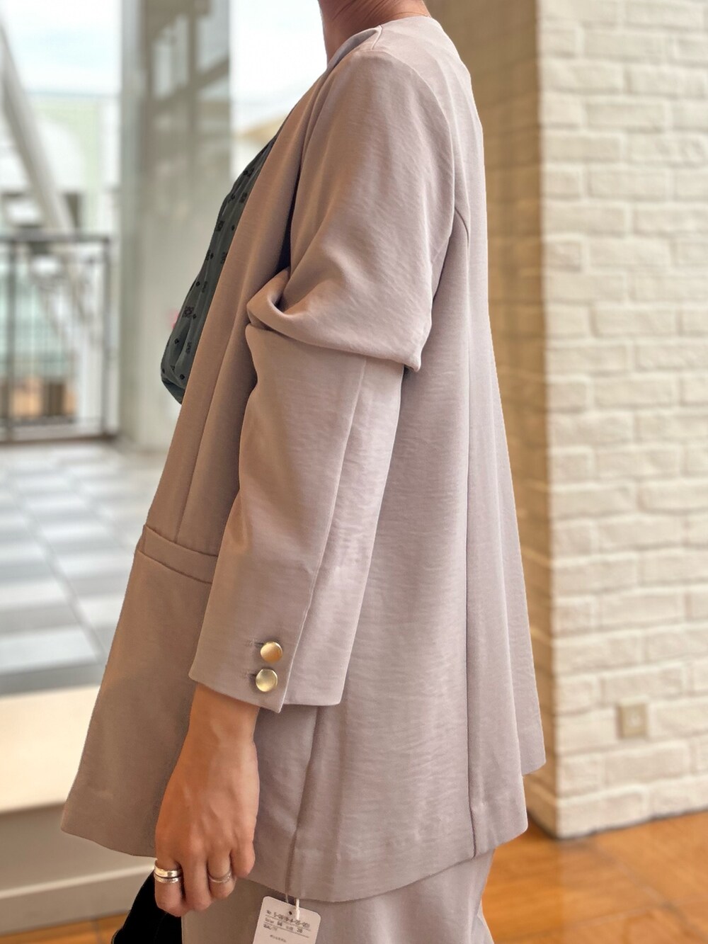 ベージュ系のノーカラージャケット、ベージュ系のその他パンツ、ブルー系のシャツ/ブラウスを着用したレディースの秋コーディネートの2枚目の写真