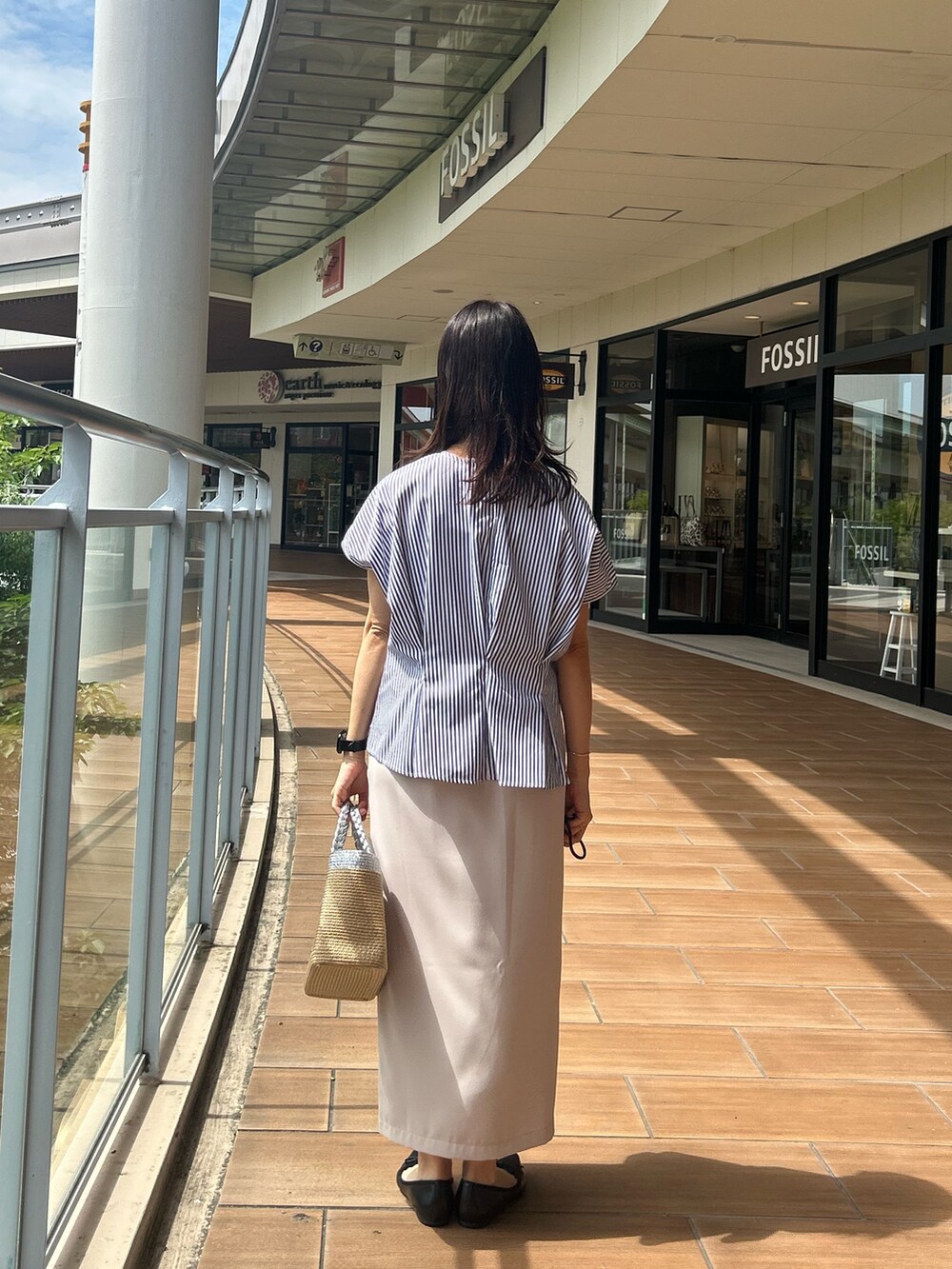 ベージュ系のスカート、ブルー系のシャツ/ブラウスを着用したレディースの夏コーディネートの3枚目の写真