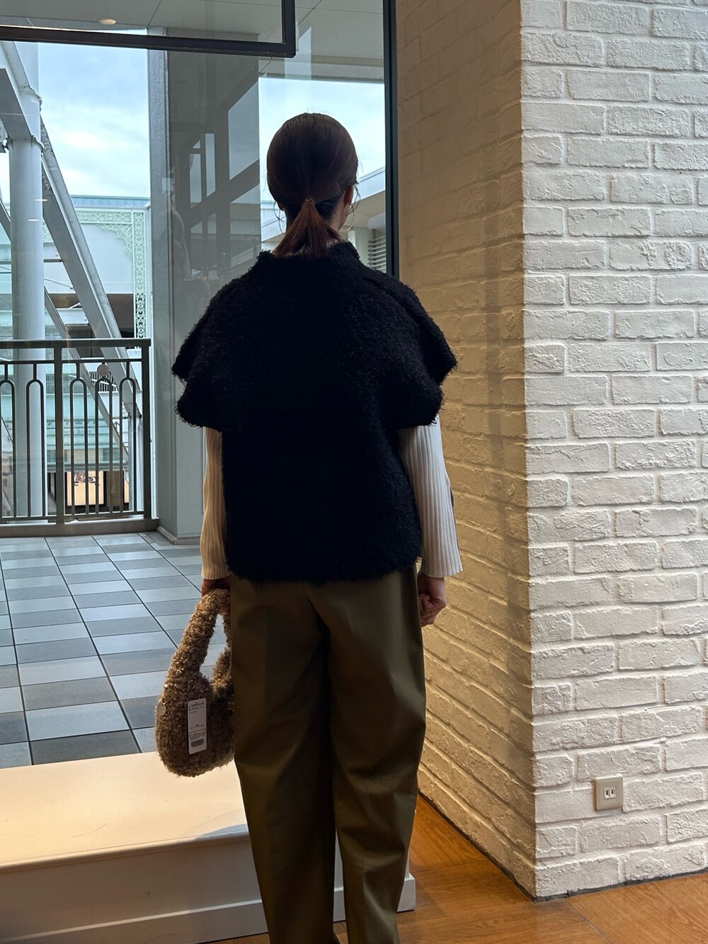 グリーン系のその他パンツ、ベージュ系のトートバッグ、ホワイト系のニット/セーターを着用したレディースの秋コーディネートの2枚目の写真