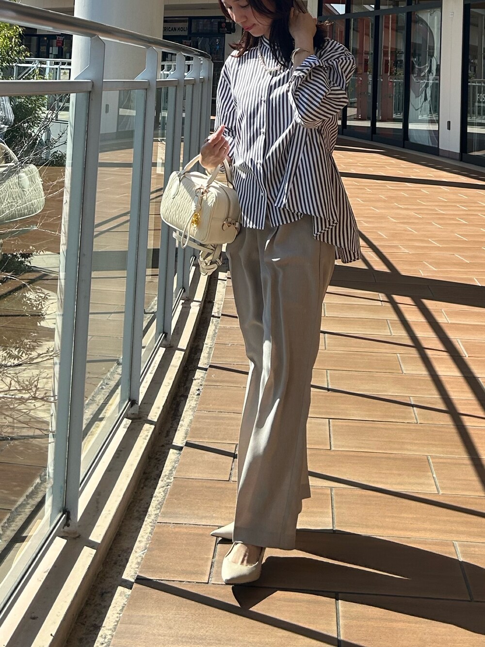 ベージュ系のその他パンツ、グレー系のシャツ/ブラウスを着用したレディースの春コーディネートの7枚目の写真