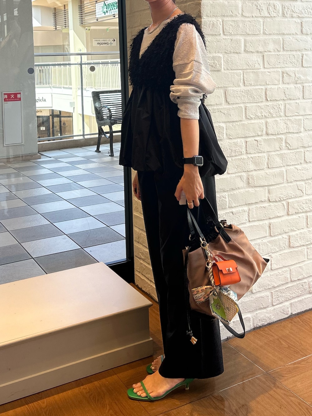 ブラック系のシャツ/ブラウス、ブラック系のその他パンツ、イエロー系のトートバッグを着用したレディースの秋コーディネートの3枚目の写真