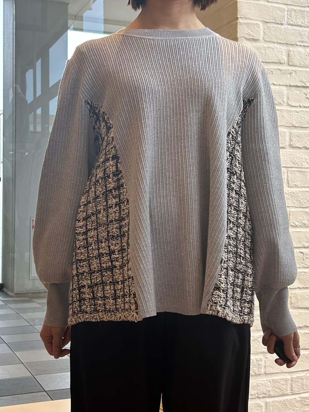 グレー系のニット/セーター、ブラック系のその他パンツ、ホワイト系のボストンバッグを着用したレディースの冬コーディネートの4枚目の写真